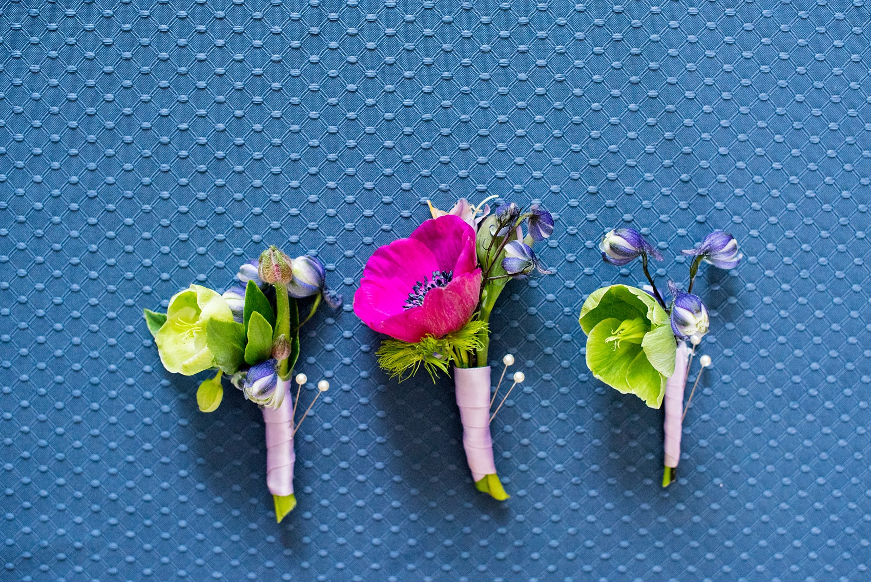 Mikkel Paige Photography photo of an anniversary session with colorful boutonnieres of fuchsia and purple, including anemones, larkspur and helliborus flowers.