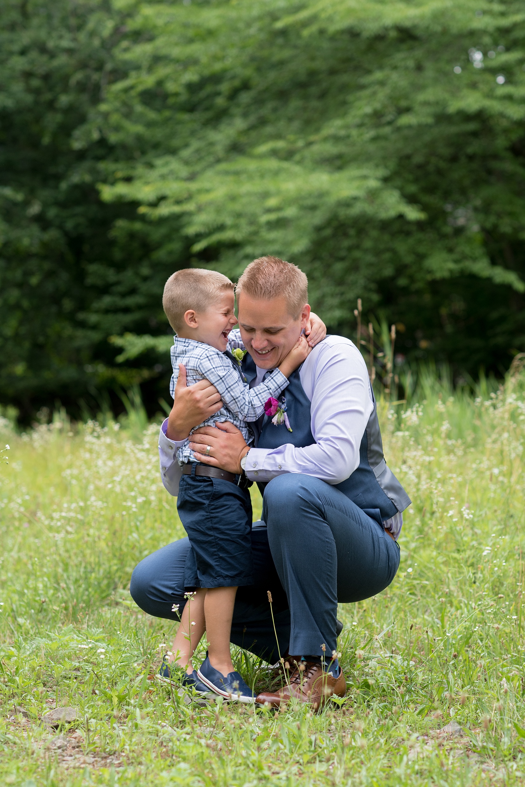 Mikkel Paige Photography photo of an anniversary session with the bride and groom's son ring bearers in plaid shirts and navy tie in a flower field.