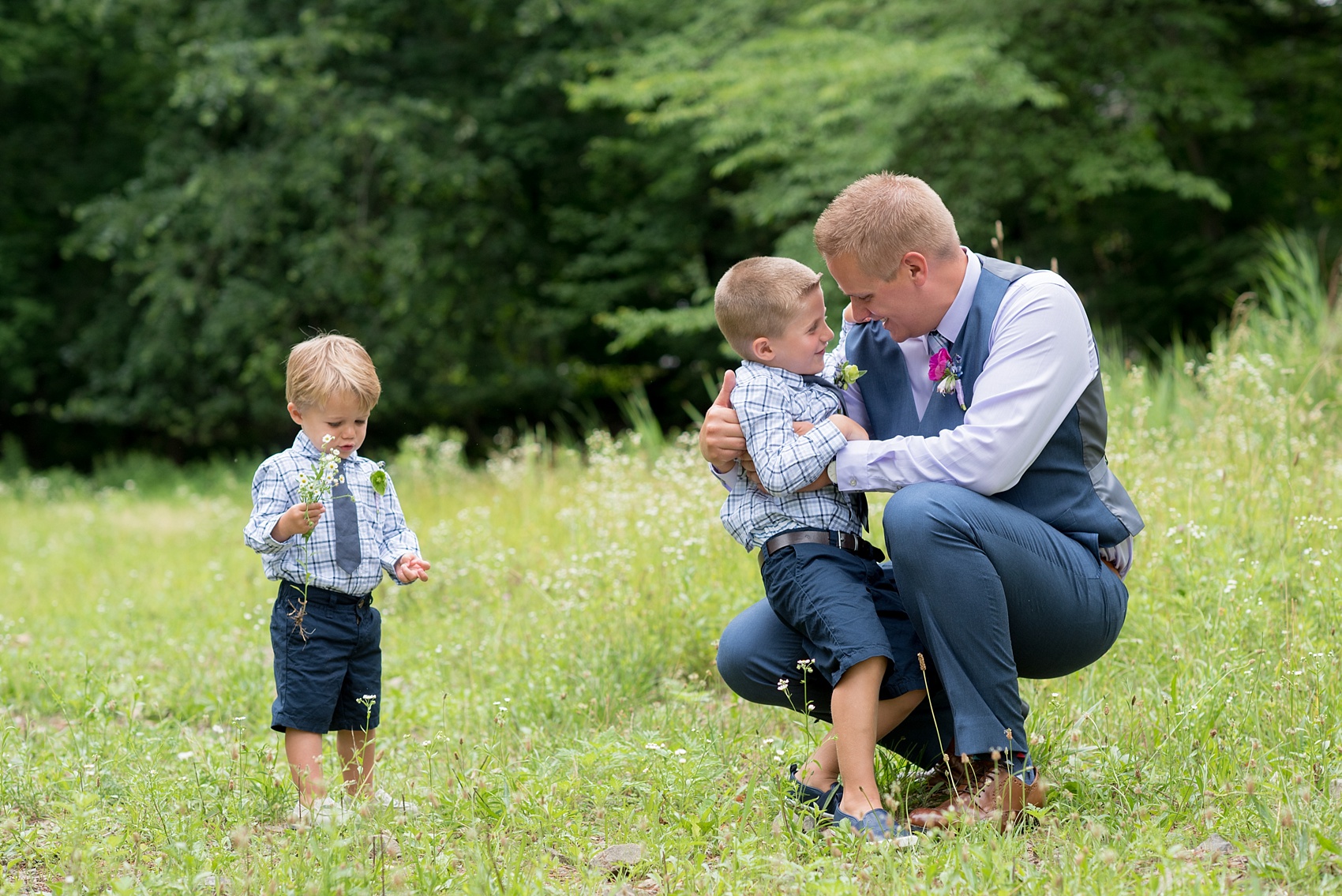 Mikkel Paige Photography photo of an anniversary session with the bride and groom's sons ring bearers in plaid shirts and navy tie in a flower field.