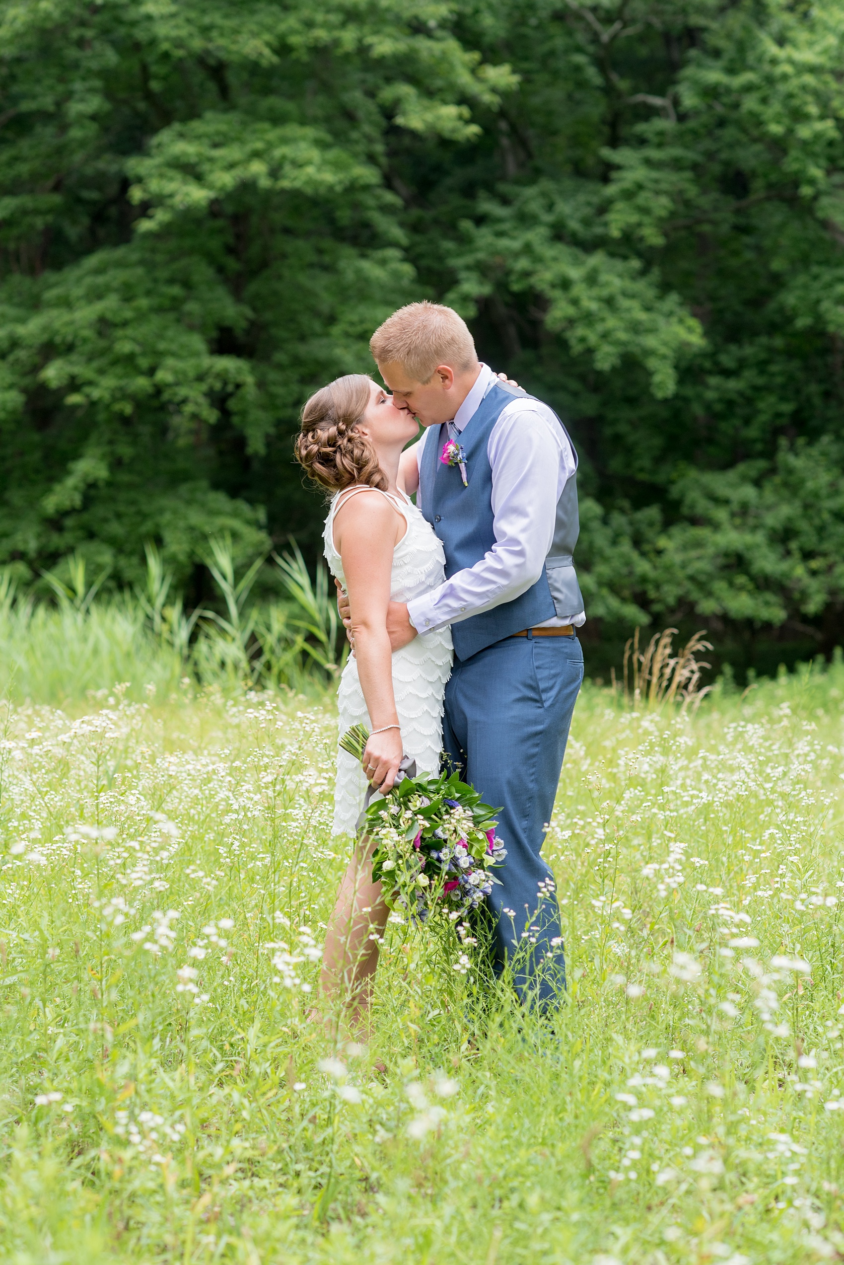 Mikkel Paige Photography photo of an anniversary session with light blue, navy and fuchsia pink accents with a bride and groom in a short white dress and blue suit and vest. 