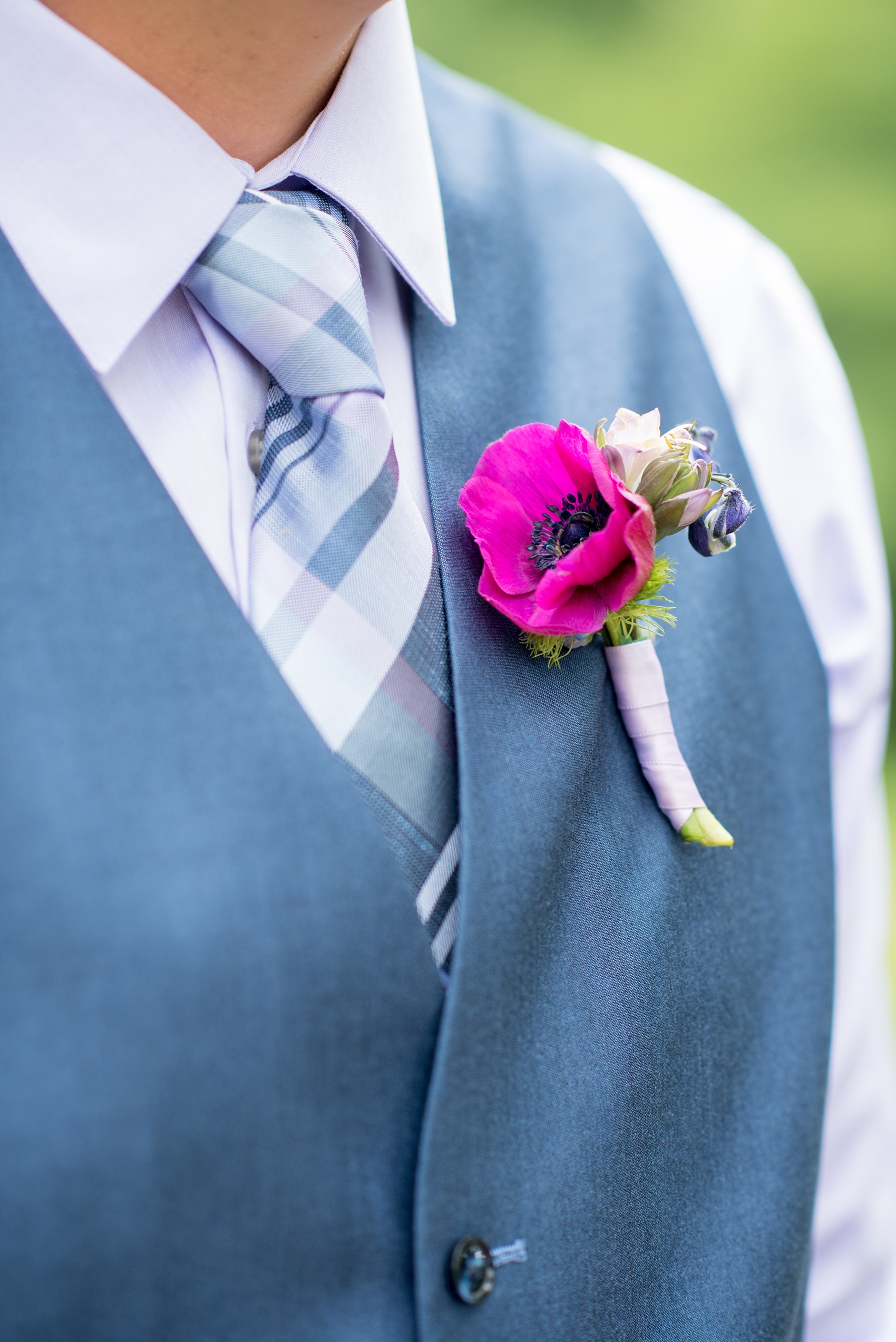 Mikkel Paige Photography photo of an anniversary session with colorful boutonnieres of fuchsia and purple, including anemones, larkspur and helliborus flowers.