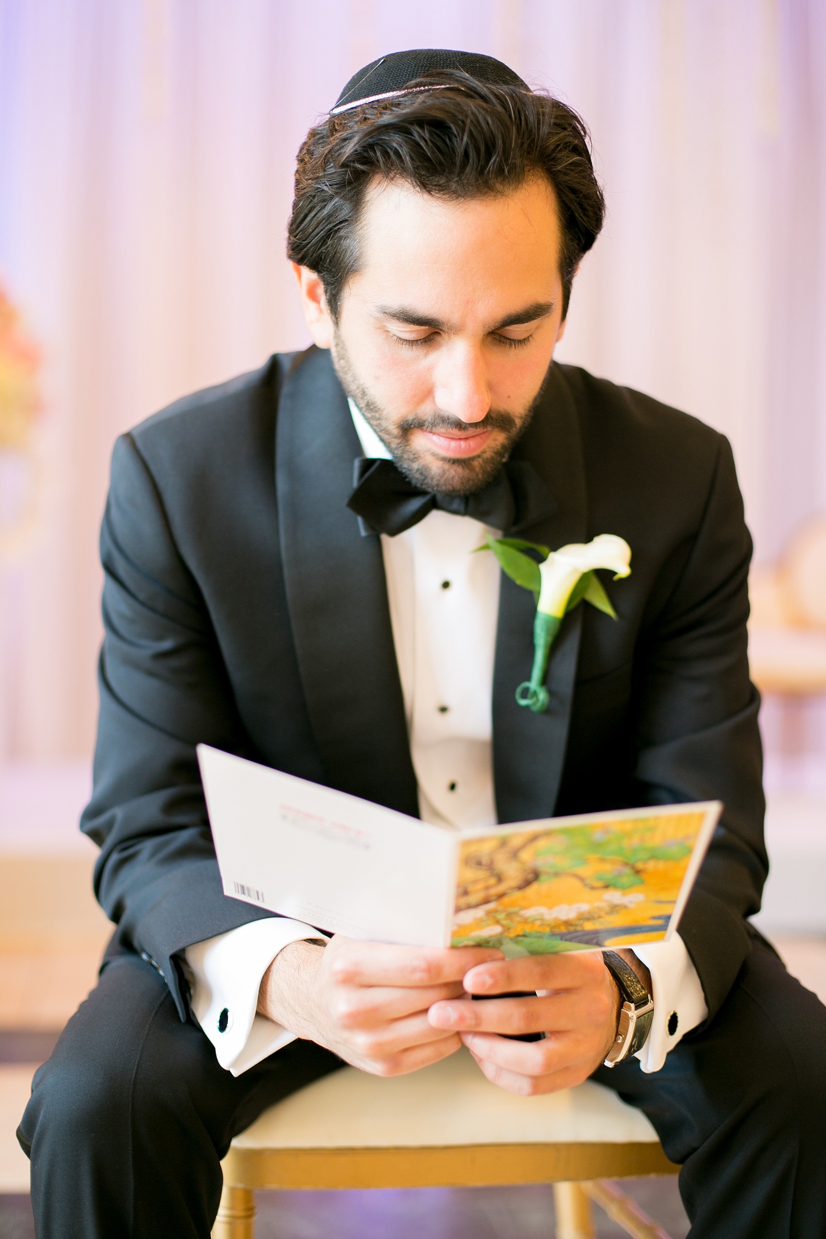 Mikkel Paige Photography photo of the groom reading a card from his wife to be on their wedding day at Temple Emanu-El in Closter, NJ.