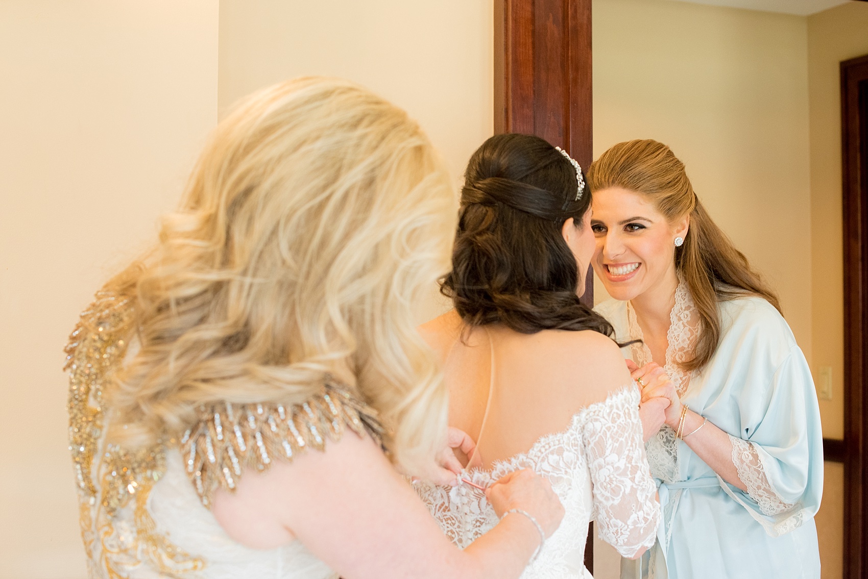 Mikkel Paige Photography photo of the bride's mother helping her into her Inbal Dror gown on her wedding day at Temple Emanu-El in Closter, NJ.