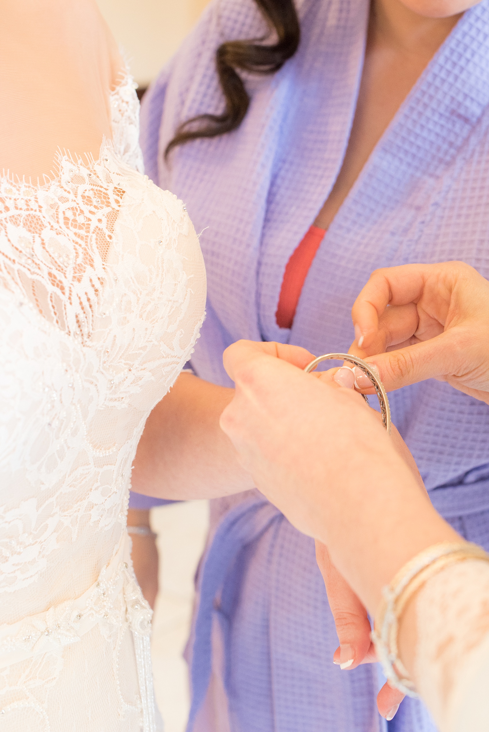 Mikkel Paige Photography photo of the bride's sisters helping her into preppare for her wedding day at Temple Emanu-El in Closter, NJ. 