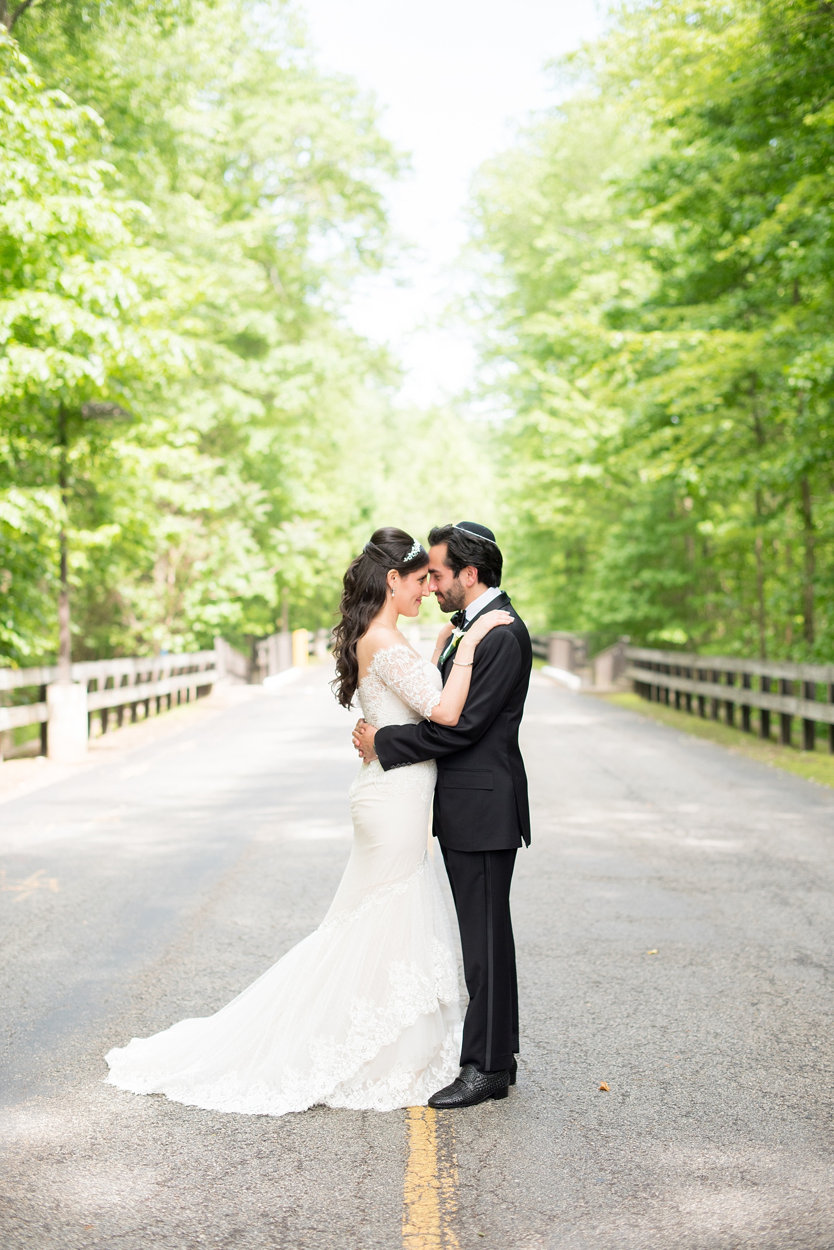 Mikkel Paige Photography photo of the bride in her long sleeve Inbal Dror gown and groom on their wedding day at Temple Emanu-El in Closter, NJ. 