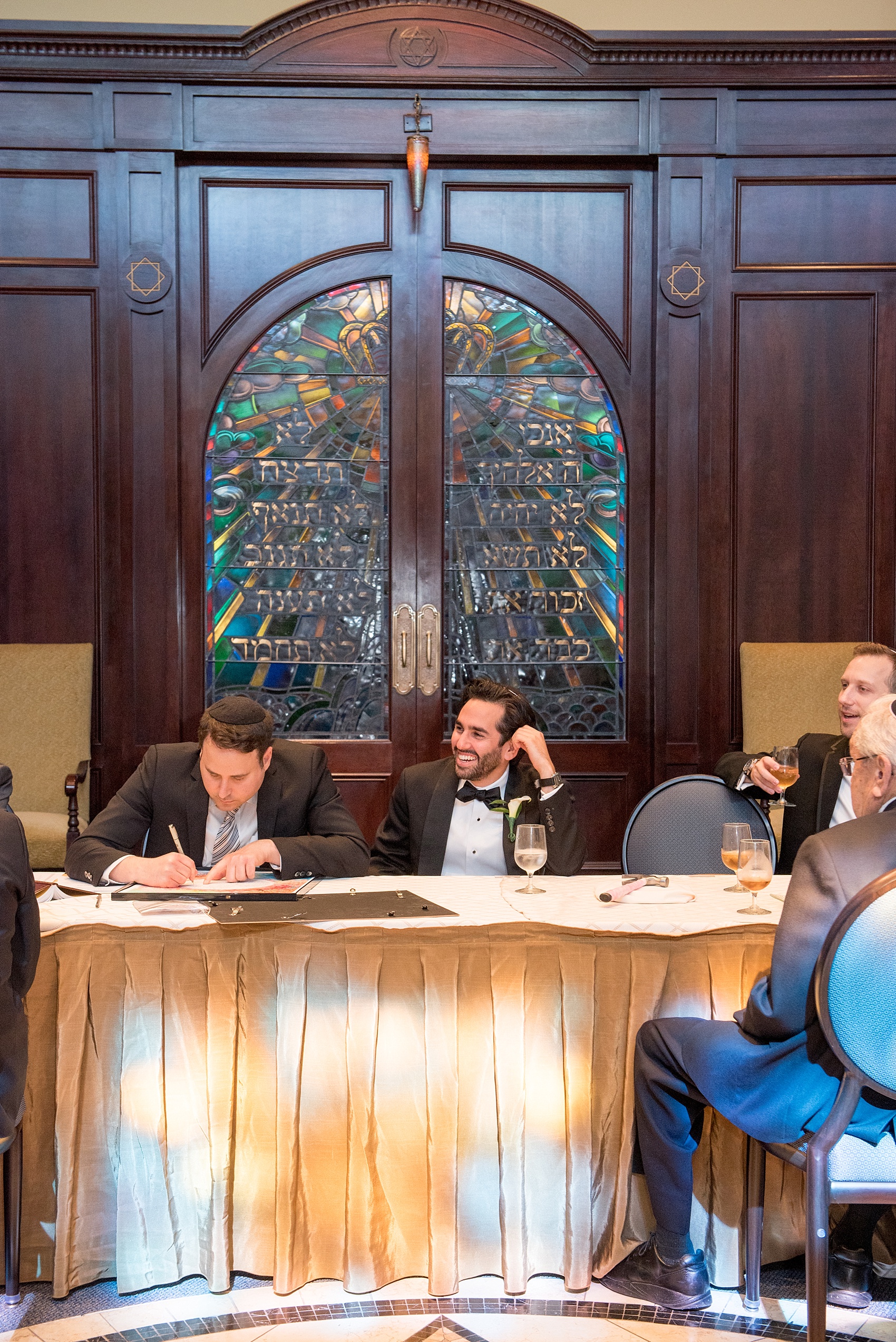 Mikkel Paige Photography photo of the groom at his Jewish religion tish at Temple Emanu-El in Closter, NJ.