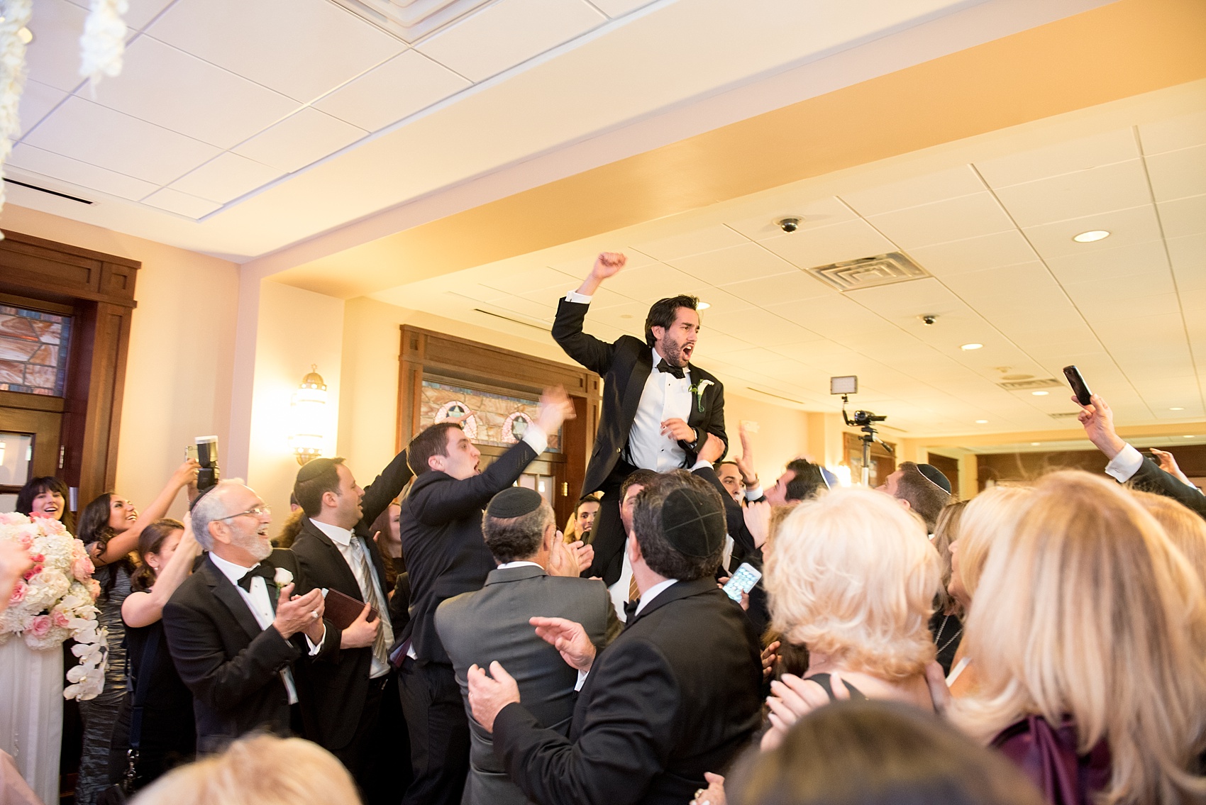 Mikkel Paige Photography photo of the groom paraded away at the bedekan during a traditional Jewish ceremony at Temple Emanu-El in Closter, NJ.