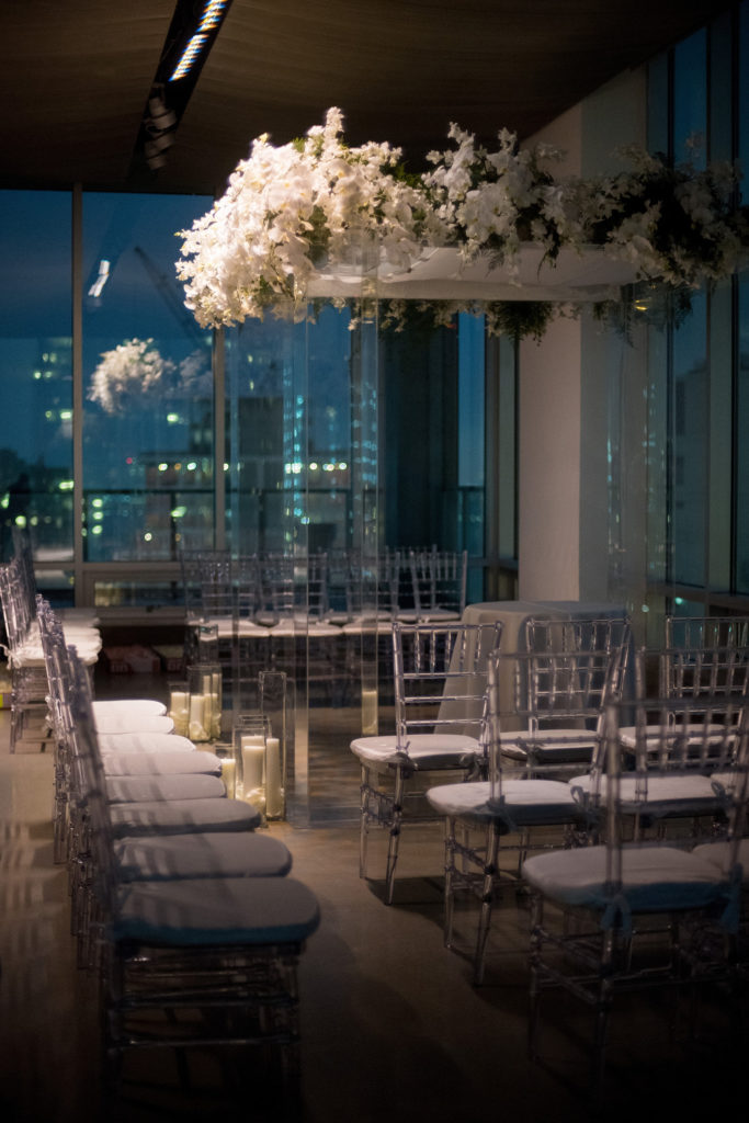 Mikkel Paige Photography wedding photos at The Glasshouses NYC. Unique clear plastic chuppah decorated with white orchids in a modern setting.