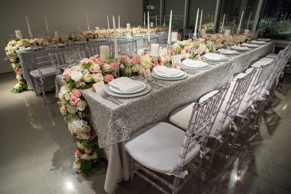 Mikkel Paige Photography wedding photos at The Glasshouses NYC. Luxury rectangle tables with silver sparkly tablecloths and floral garland with pink and white roses at a posh Manhattan venue.