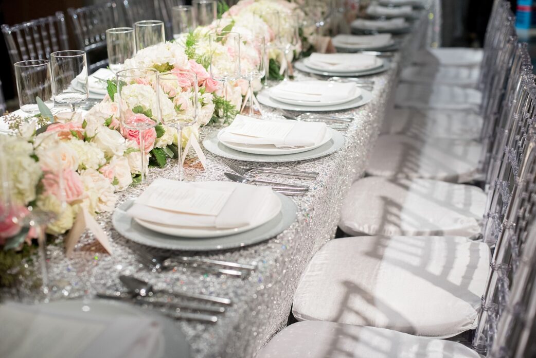 Mikkel Paige Photography wedding photos at The Glasshouses NYC. Luxury rectangle tables with silver sparkly tablecloths and floral garland with pink and white roses at a posh Manhattan venue.