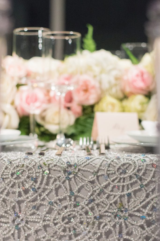 Mikkel Paige Photography wedding photos at The Glasshouses NYC. Luxury rectangle tables with silver sparkly tablecloths and floral garland with pink and white roses at a posh Manhattan venue.