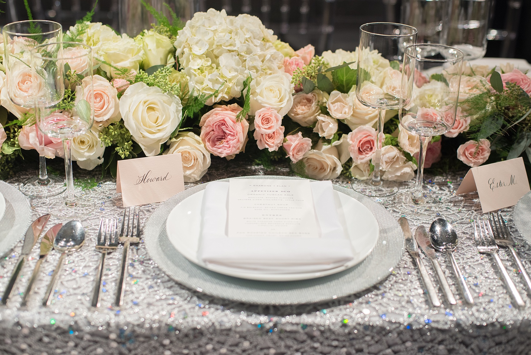 Mikkel Paige Photography wedding photos at The Glasshouses NYC. Luxury rectangle tables with silver sparkly tablecloths and floral garland with pink and white roses at a posh Manhattan venue.