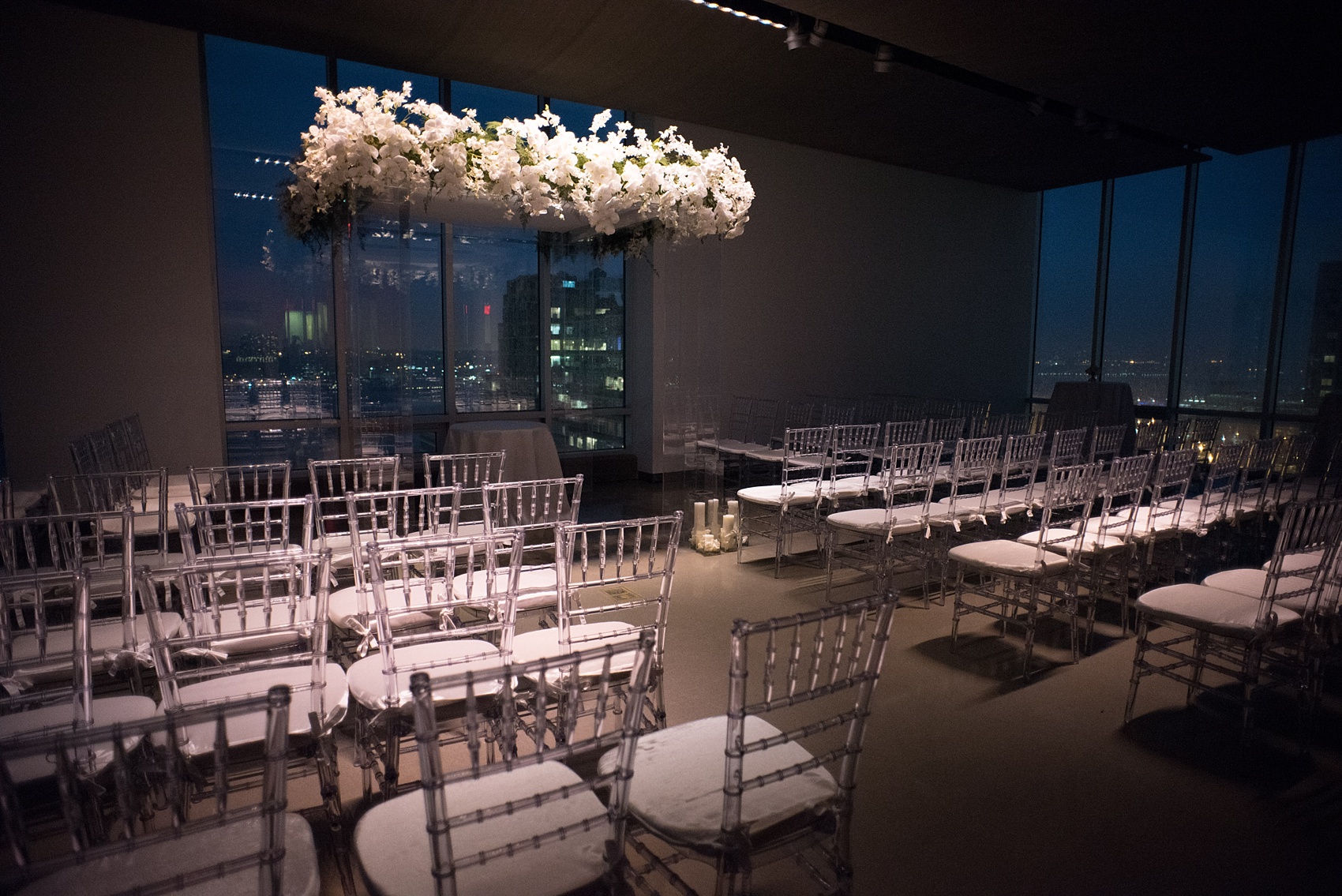 Mikkel Paige Photography wedding photos at The Glasshouses NYC. Unique clear plastic chuppah decorated with white orchids in a modern setting. 