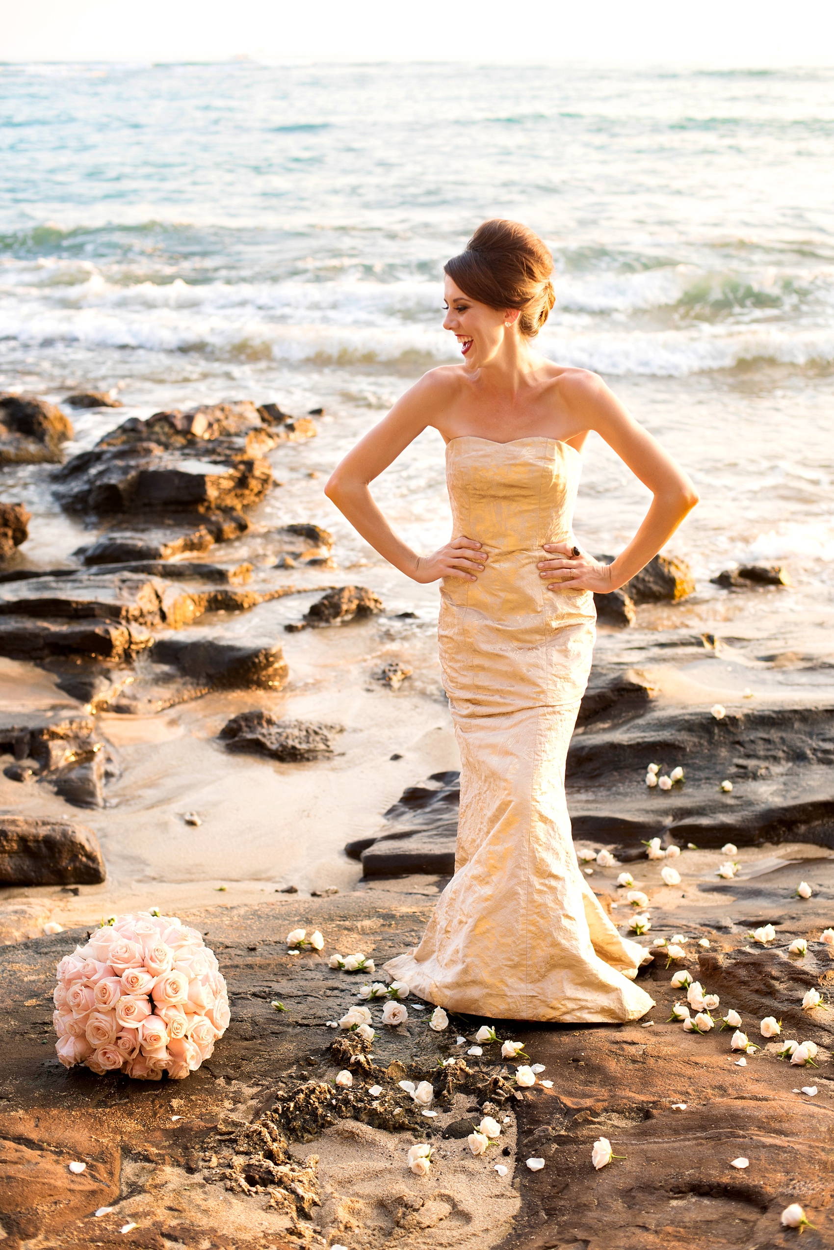 Mikkel Paige Photography photos of a bridal session on beach in Oahu. Golden hour bride with beehive up do, metallic gown and rose pomanders on the lava rock shore.