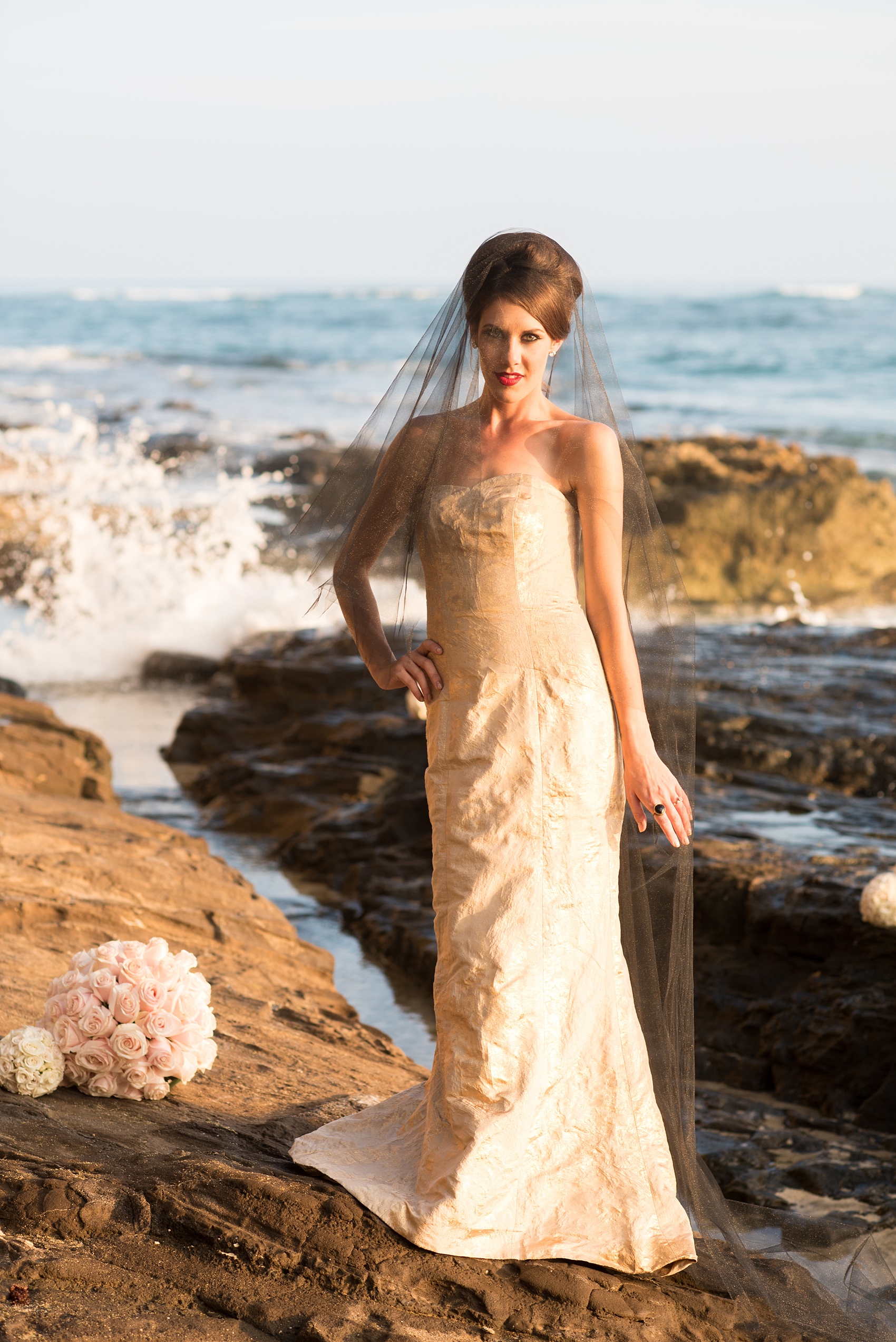 Mikkel Paige Photography photos of a bridal session on beach in Oahu. Golden hour bride with beehive up do, black veil and metallic gown.