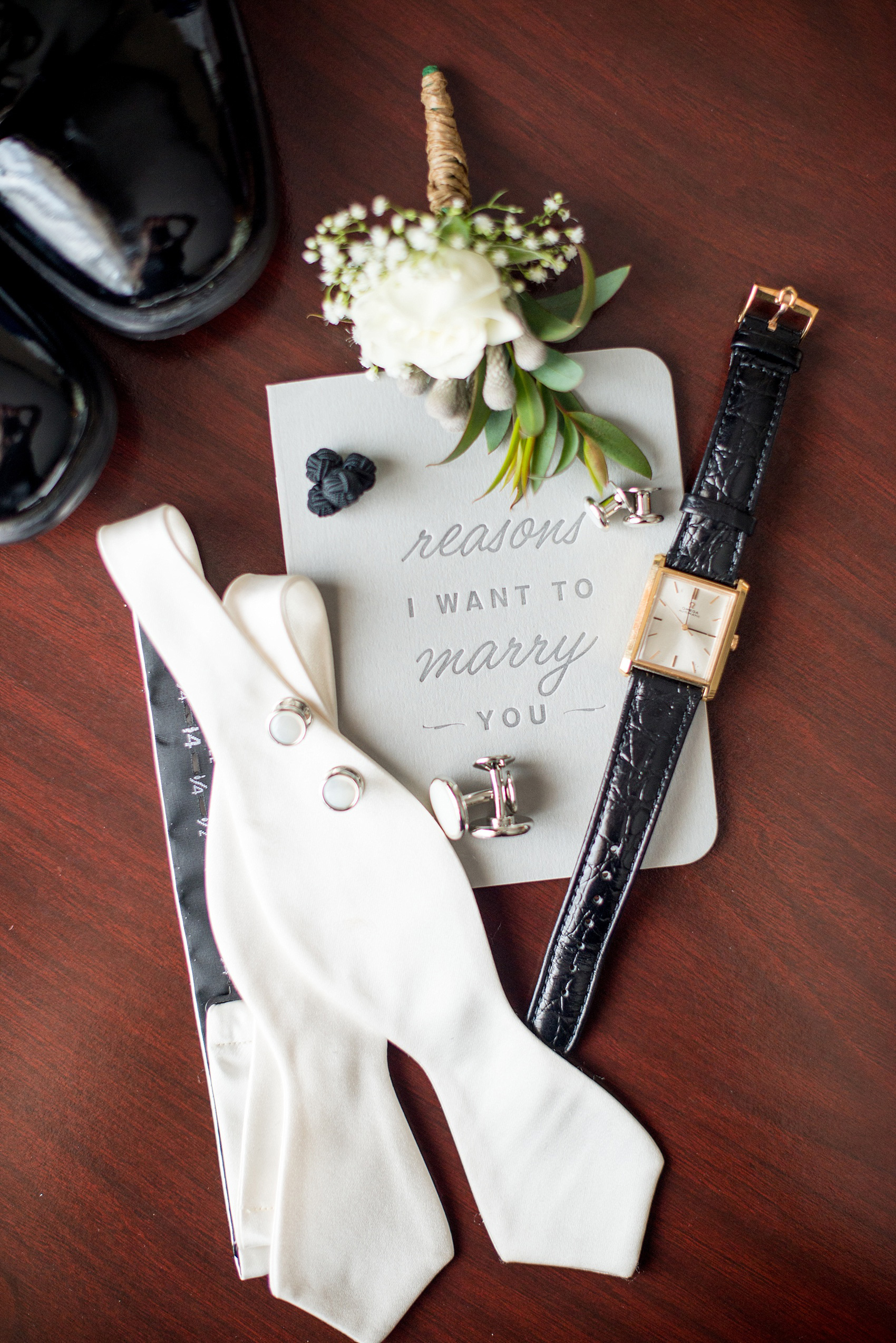 Mikkel Paige Photography photo of a wedding at the Madison Hotel in NJ. Image of the groom's bow tie, watch, cufflinks and vows.