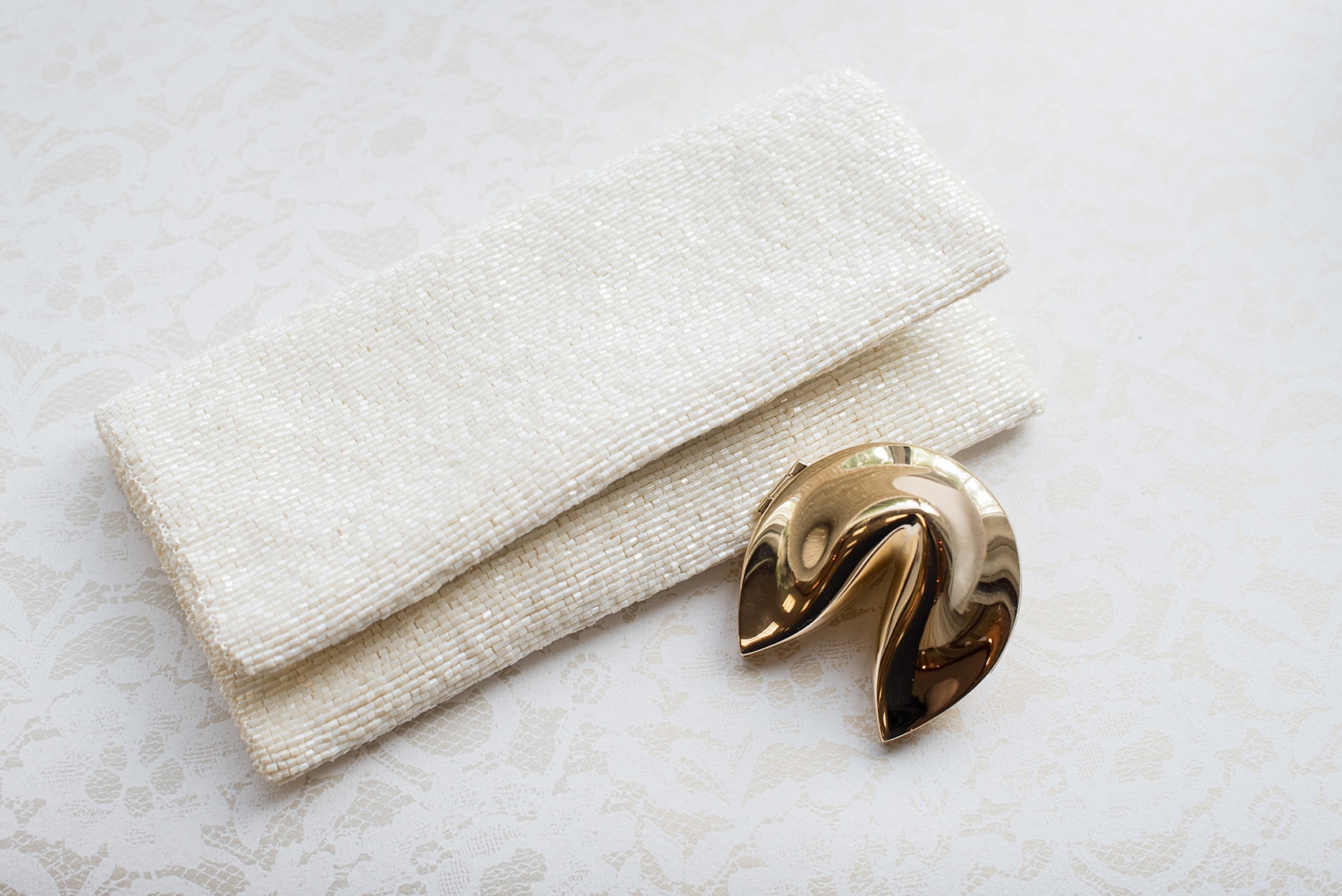 Mikkel Paige Photography photo of a wedding at the Madison Hotel in NJ. Image of the bride's beaded bridal clutch and gold fortune cookie.