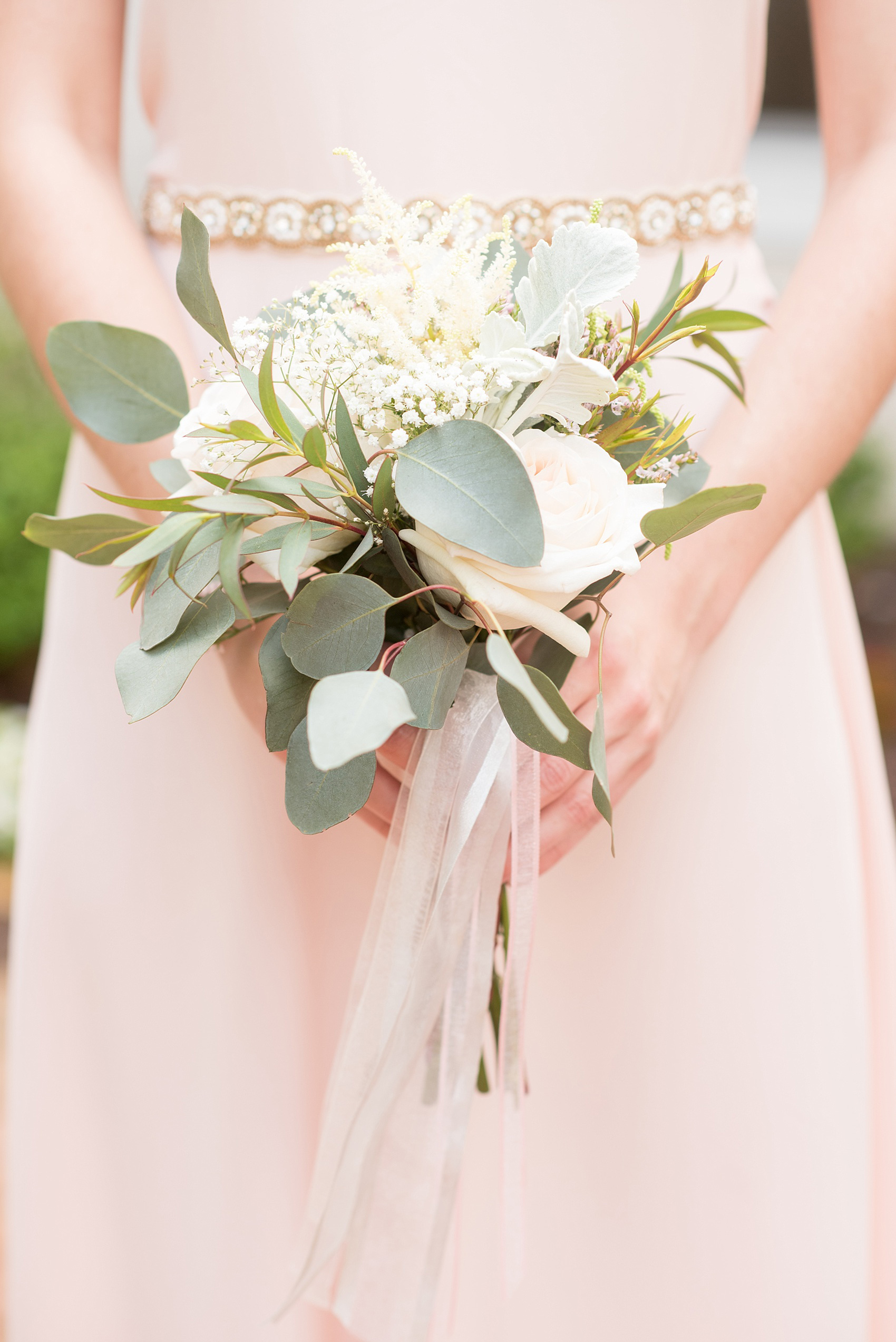 Mikkel Paige Photography photo of a wedding at Madison Hotel in NJ with the bridal party in light pink mismatched dresses with white rose and eucalyptus bouquets with long ribbons.