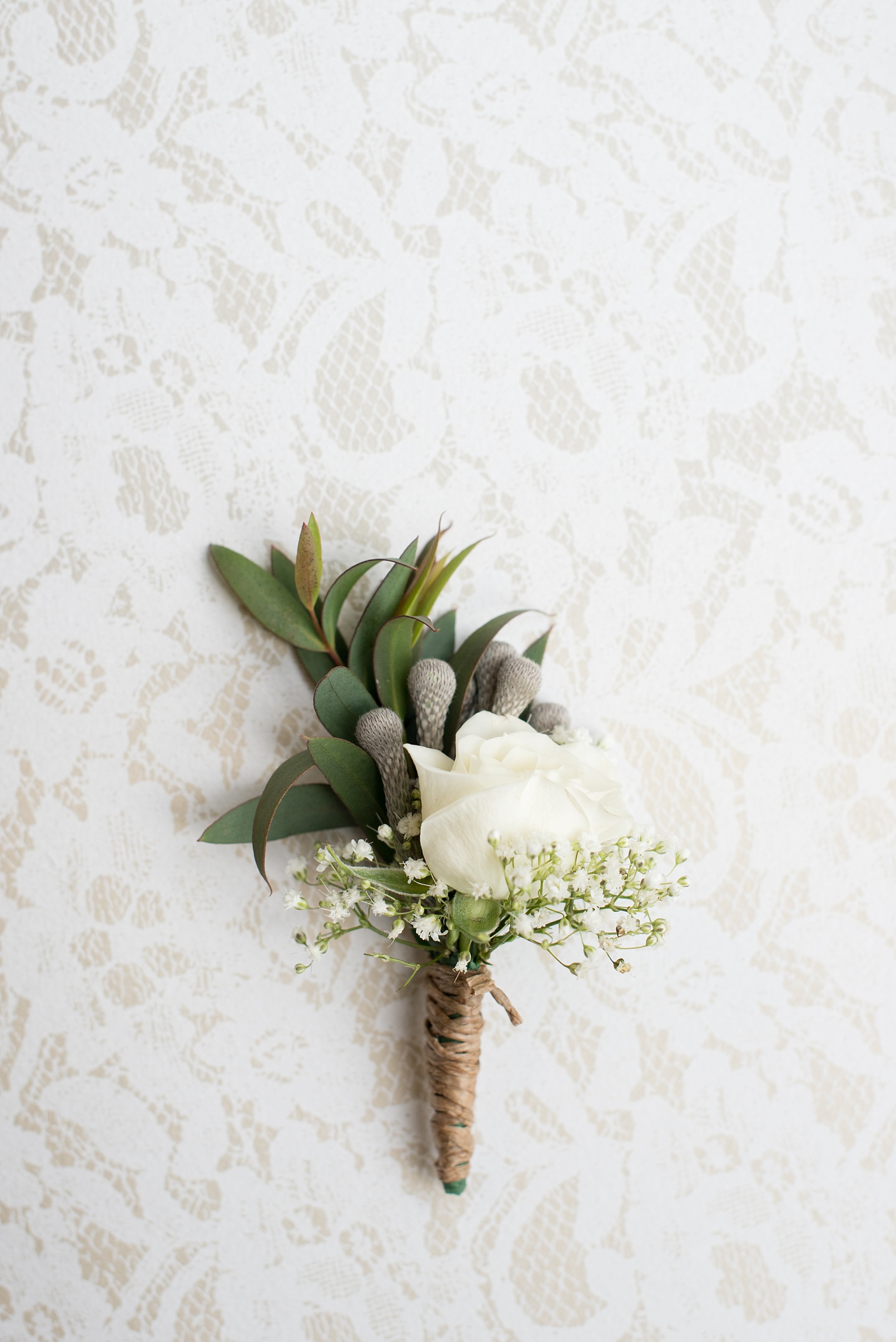 Mikkel Paige Photography photo of a wedding at the Madison Hotel in NJ. Image of the rose and baby's breath boutonnieres wrapped in twine.