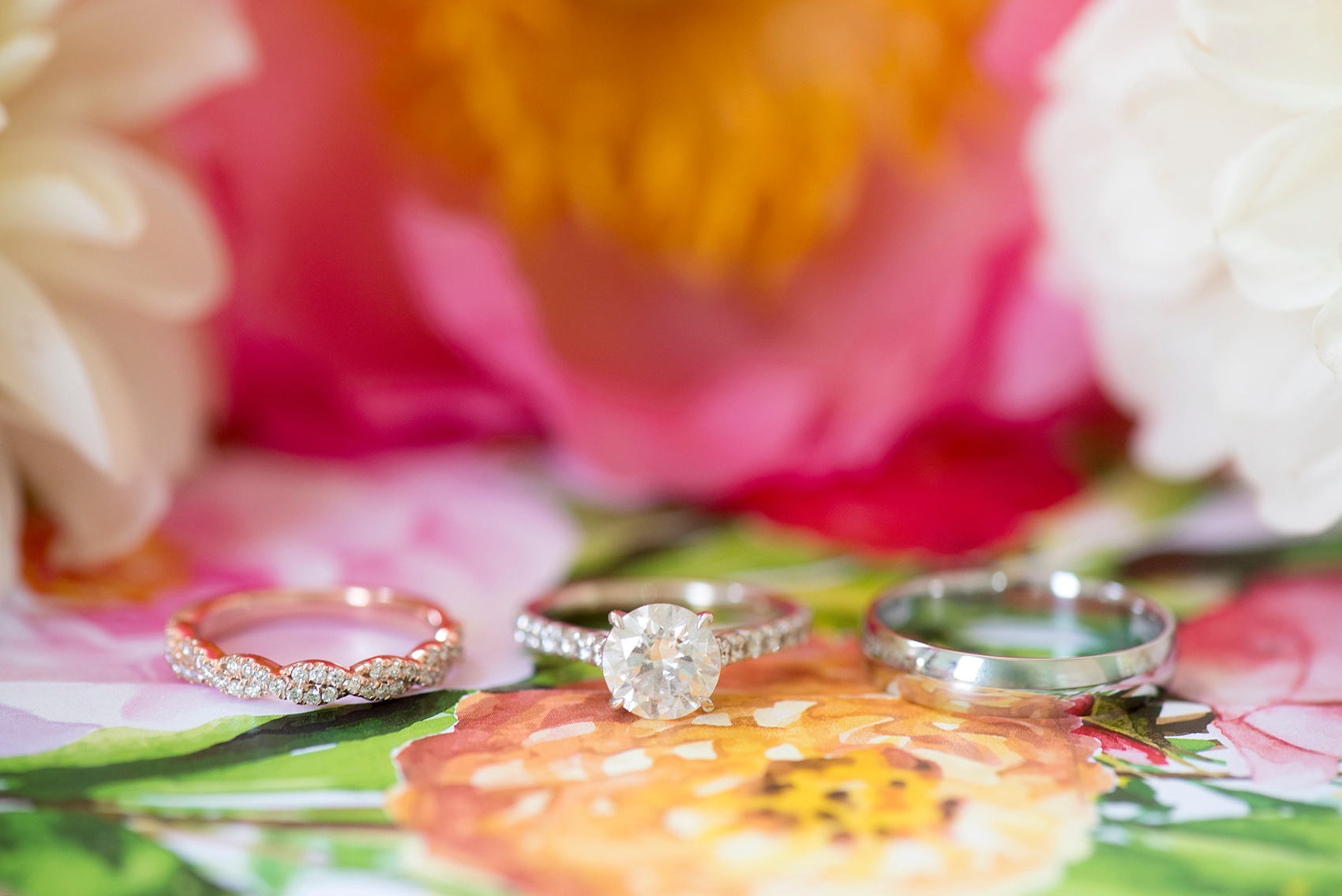 Mikkel Paige Photography wedding photos at The Merrimon-Wynne House in downtown Raleigh. Detail ring image of mixed metal rose and white gold bands with round diamond engagement on floral invitation liner.