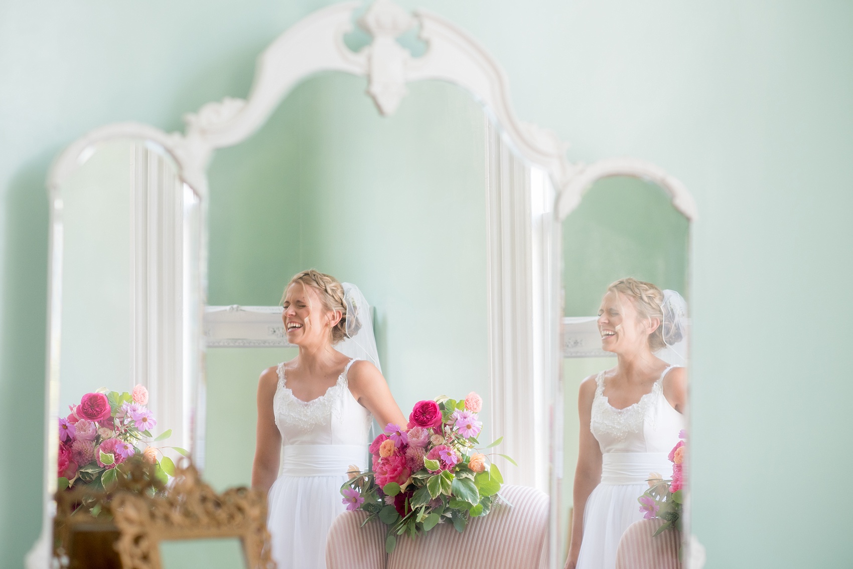 Mikkel Paige Photography wedding photos at The Merrimon-Wynne House in downtown Raleigh. The bride in a mirror image with a reverse braid crown hair up-do, low back gown and colorful bouquet by Meristem Floral. 