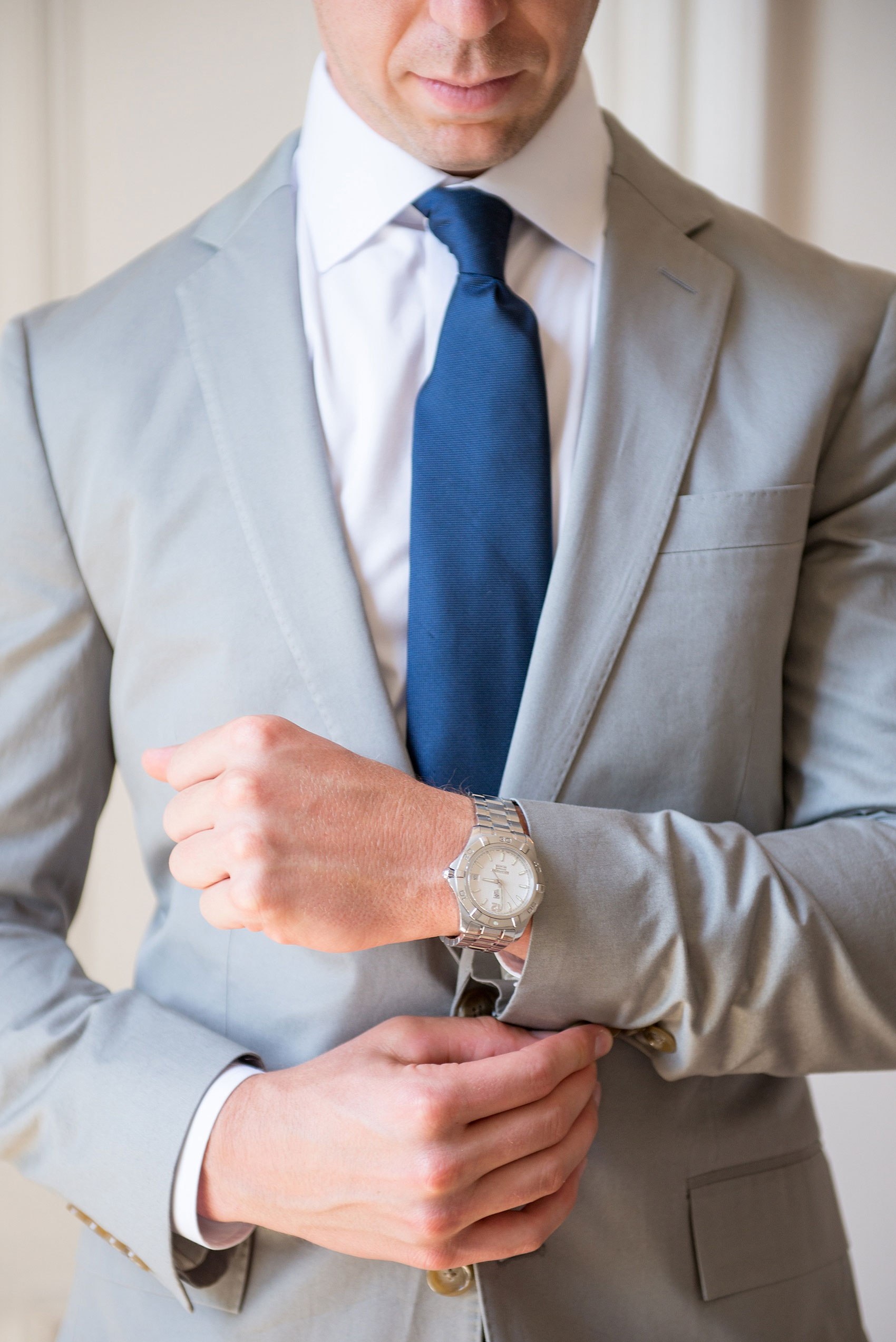 Mikkel Paige Photography wedding photos at The Merrimon-Wynne House in downtown Raleigh. The groom prepares for his day with a blue tie and grey suit.