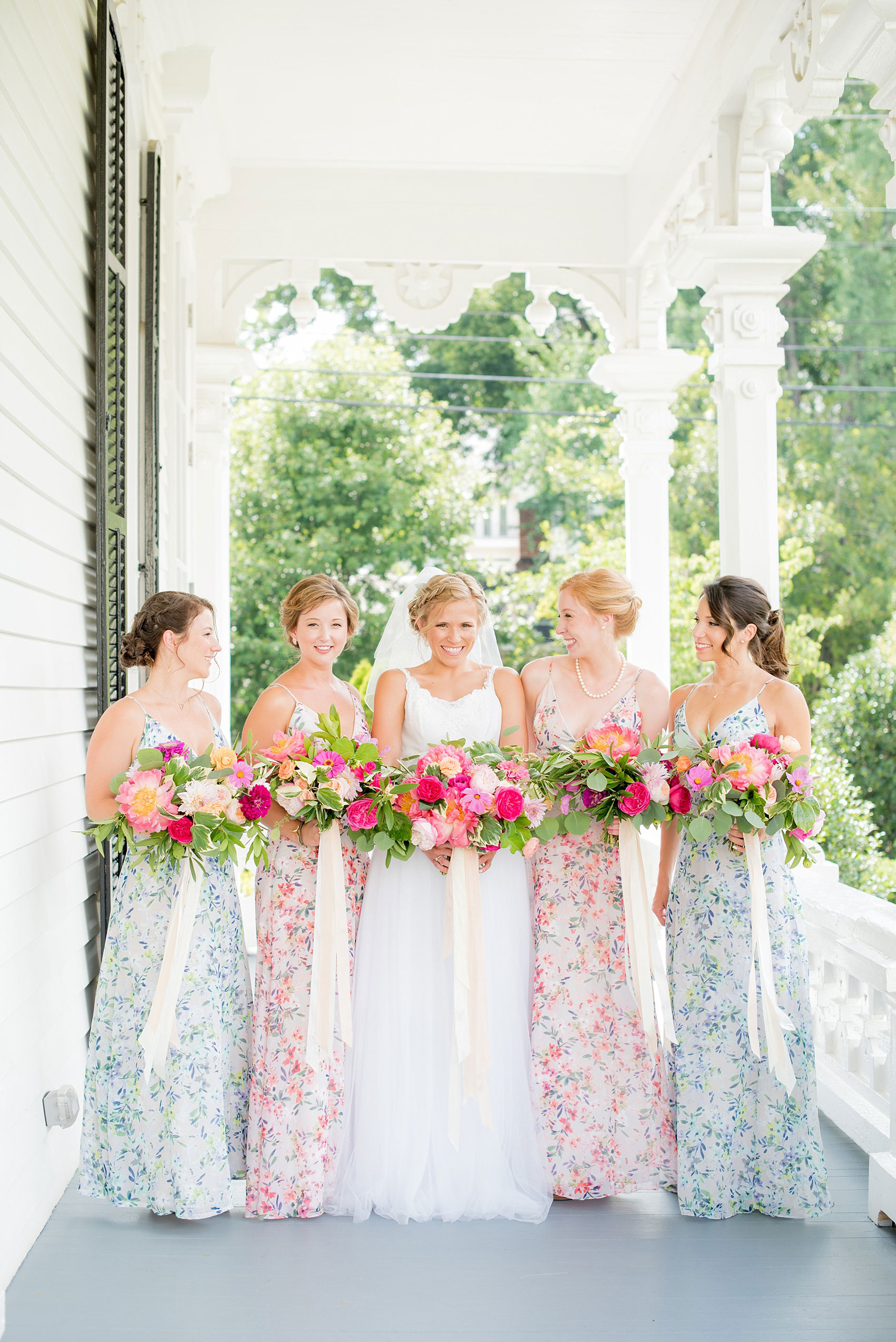 Mikkel Paige Photography wedding photos at The Merrimon-Wynne House in downtown Raleigh. Bridesmaids in floral maxi gowns with colorful pink, orange and green bouquets with peonies, eucalyptus and garden roses by Meristem Floral. 