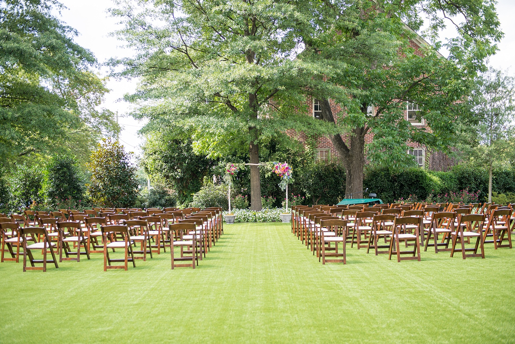 Mikkel Paige Photography wedding photos at The Merrimon-Wynne House in downtown Raleigh. Outdoor ceremony with bright floral arch.