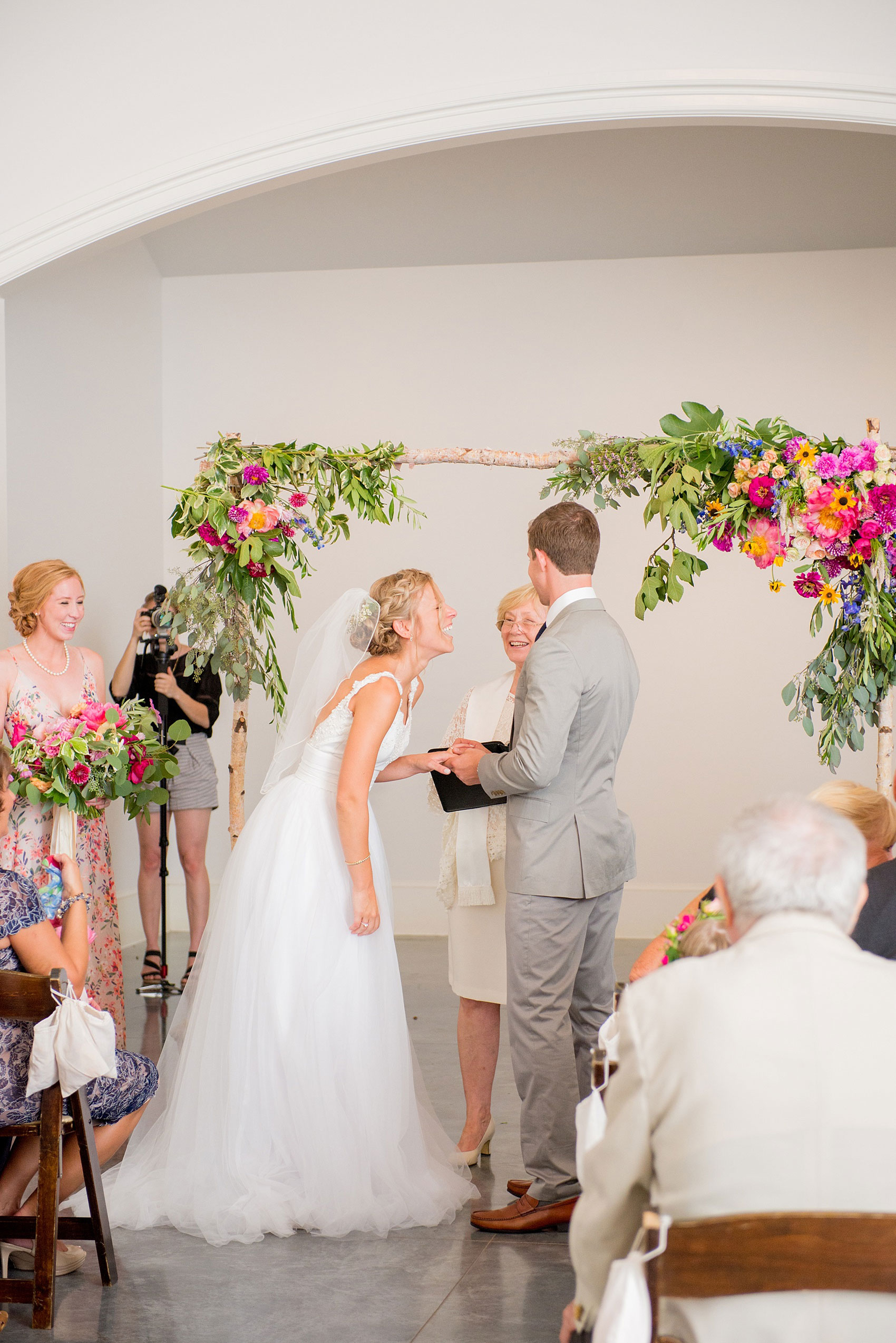 Mikkel Paige Photography wedding photos at The Merrimon-Wynne House in downtown Raleigh. The bride and groom exchanging vows in front of their floral ceremony arch.