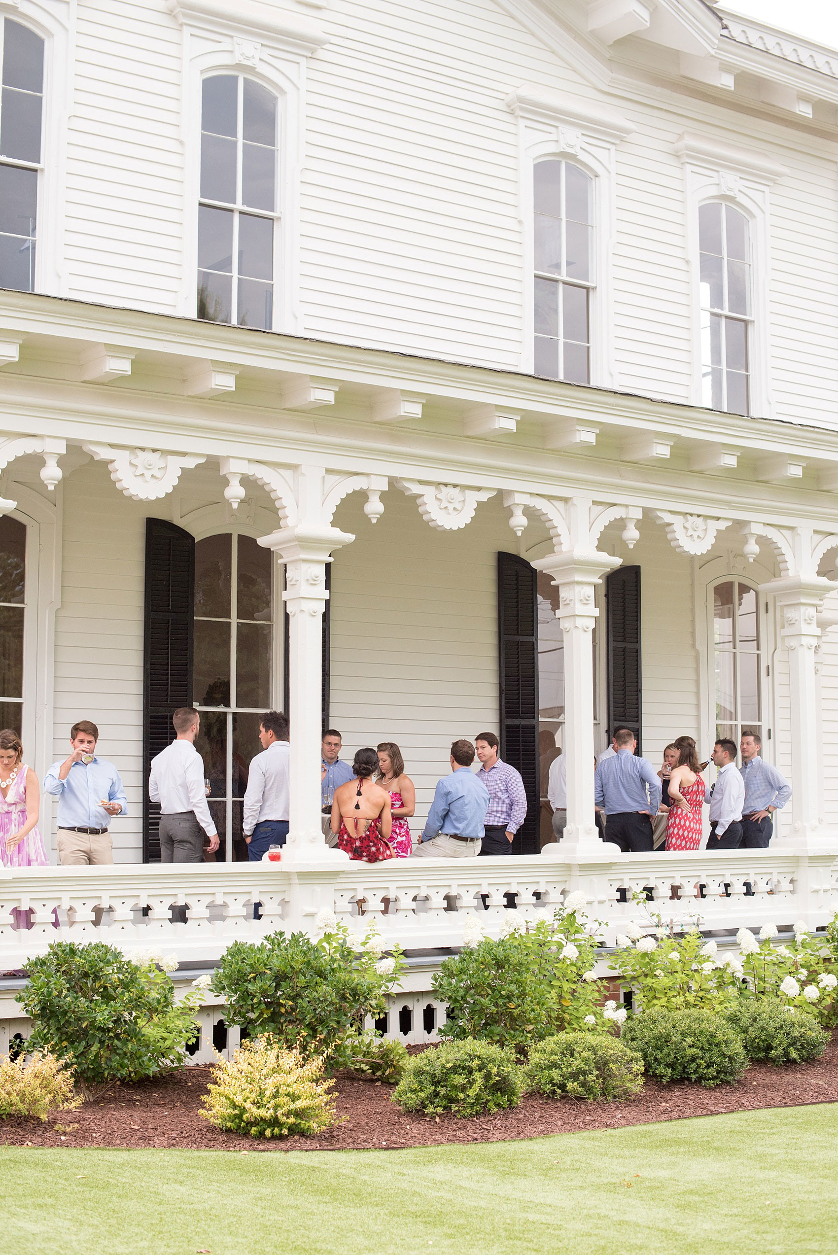 Mikkel Paige Photography wedding photos at The Merrimon-Wynne House in downtown Raleigh. A photo of the cocktail hour and guest enjoying the southern porch at the venue.