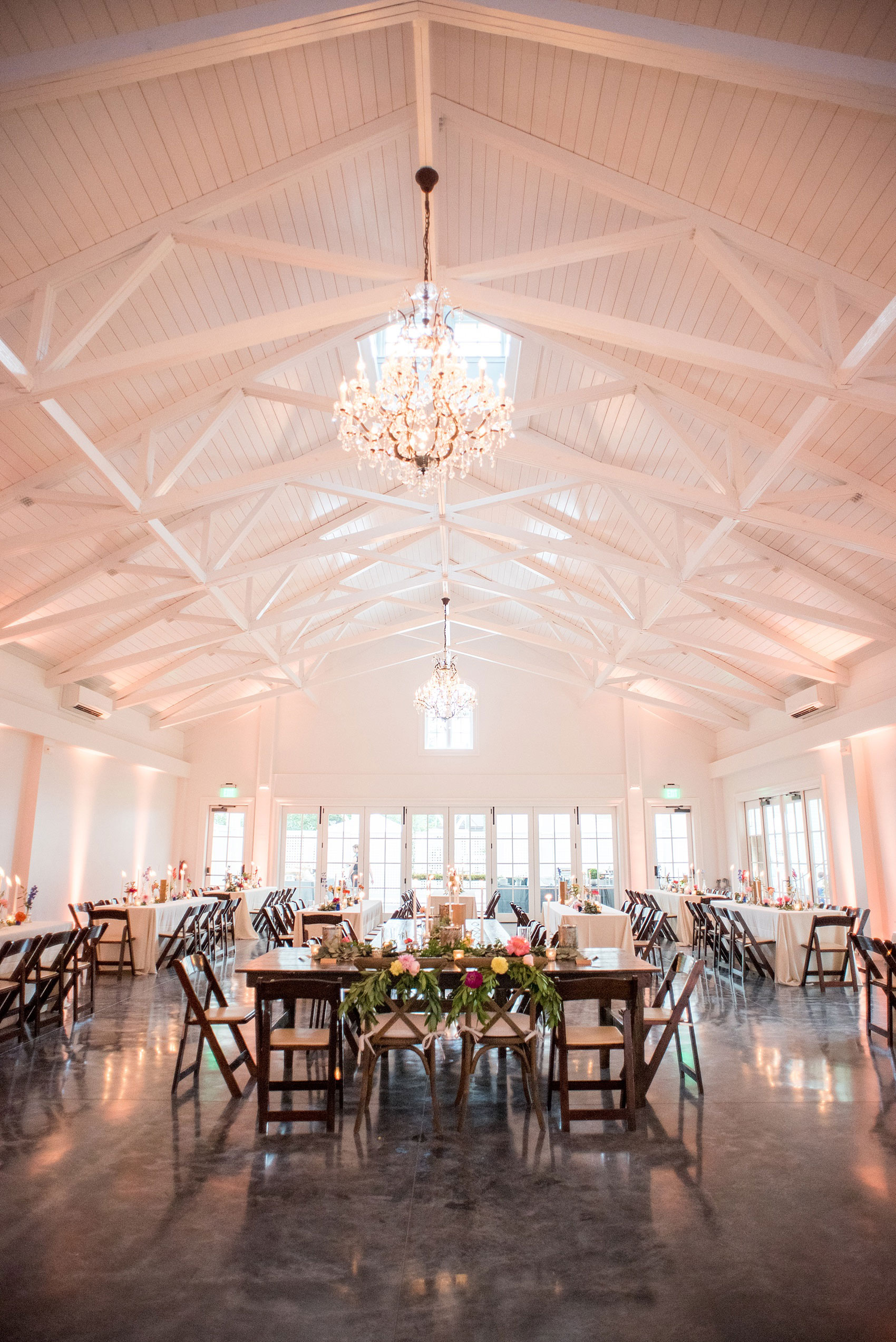 Mikkel Paige Photography wedding photos at The Merrimon-Wynne House in downtown Raleigh. A picture of the carriage house with farm tables and bud vases.