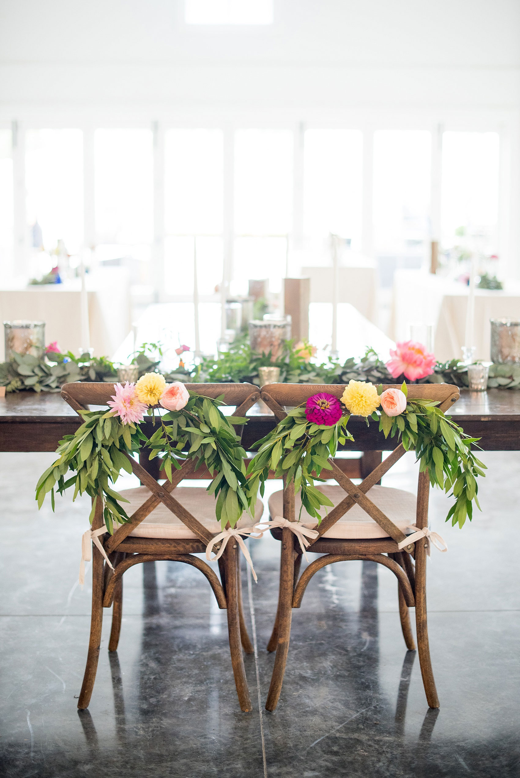 Mikkel Paige Photography wedding photos at The Merrimon-Wynne House in downtown Raleigh. A picture of the carriage house with bride and groom farm seats decorated in garland with eucalyptus and dahlia flowers.