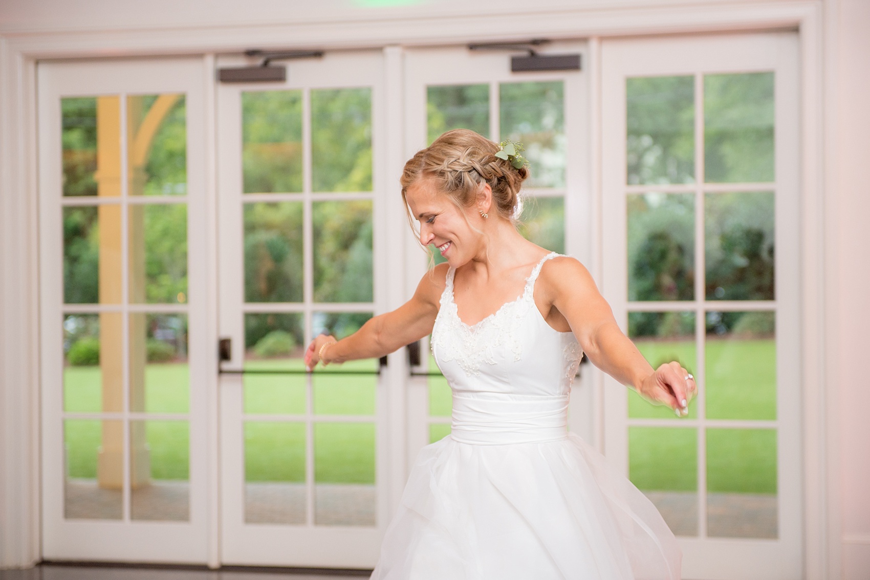 Mikkel Paige Photography wedding photos at The Merrimon-Wynne House in downtown Raleigh. A picture of the carriage house reception. The bride takes a twirl on the dance floor in her convertible wedding dress! 