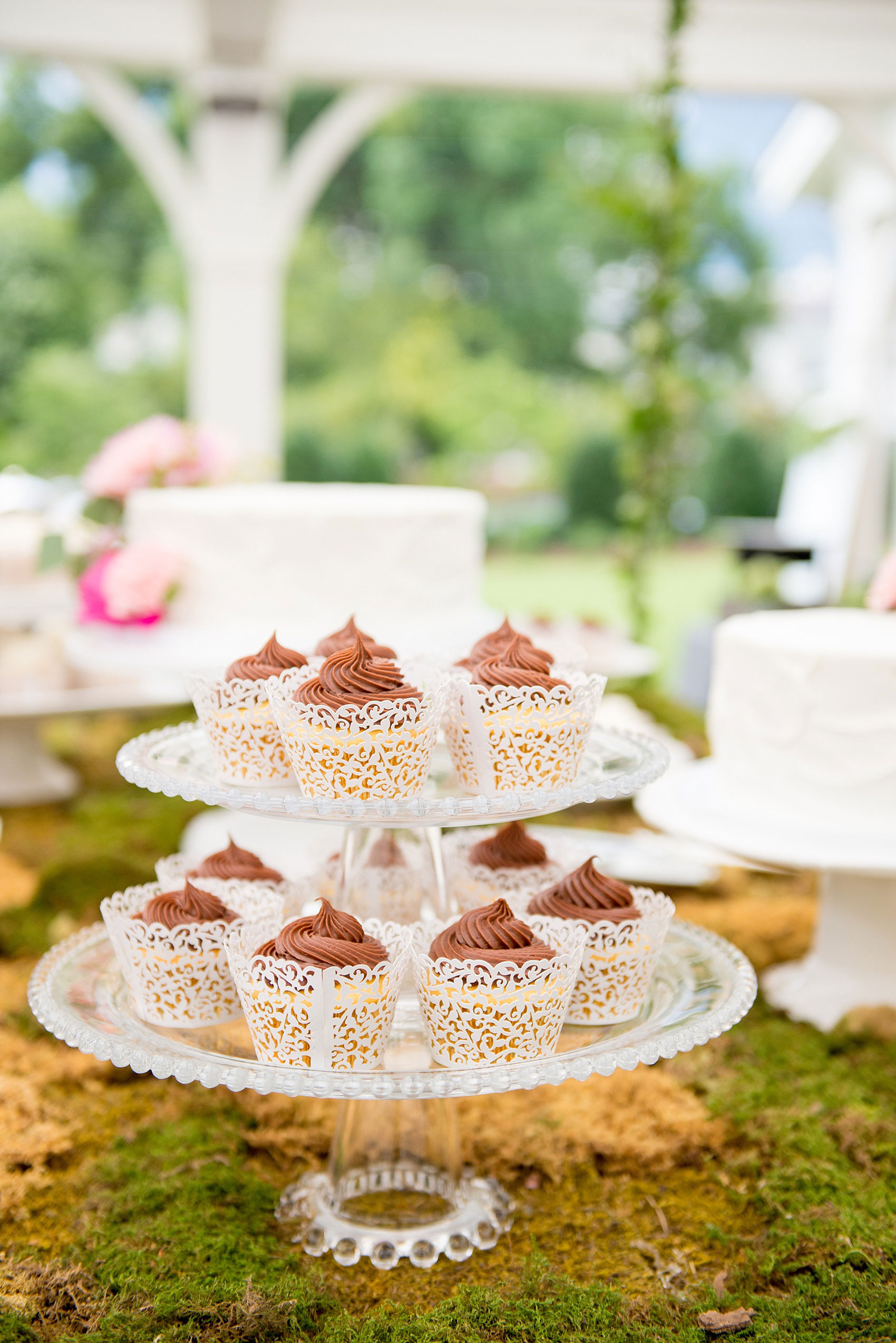 Mikkel Paige Photography wedding photos at The Merrimon-Wynne House in downtown Raleigh. A picture of the moss covered dessert table with multiple white cake and cupcakes.