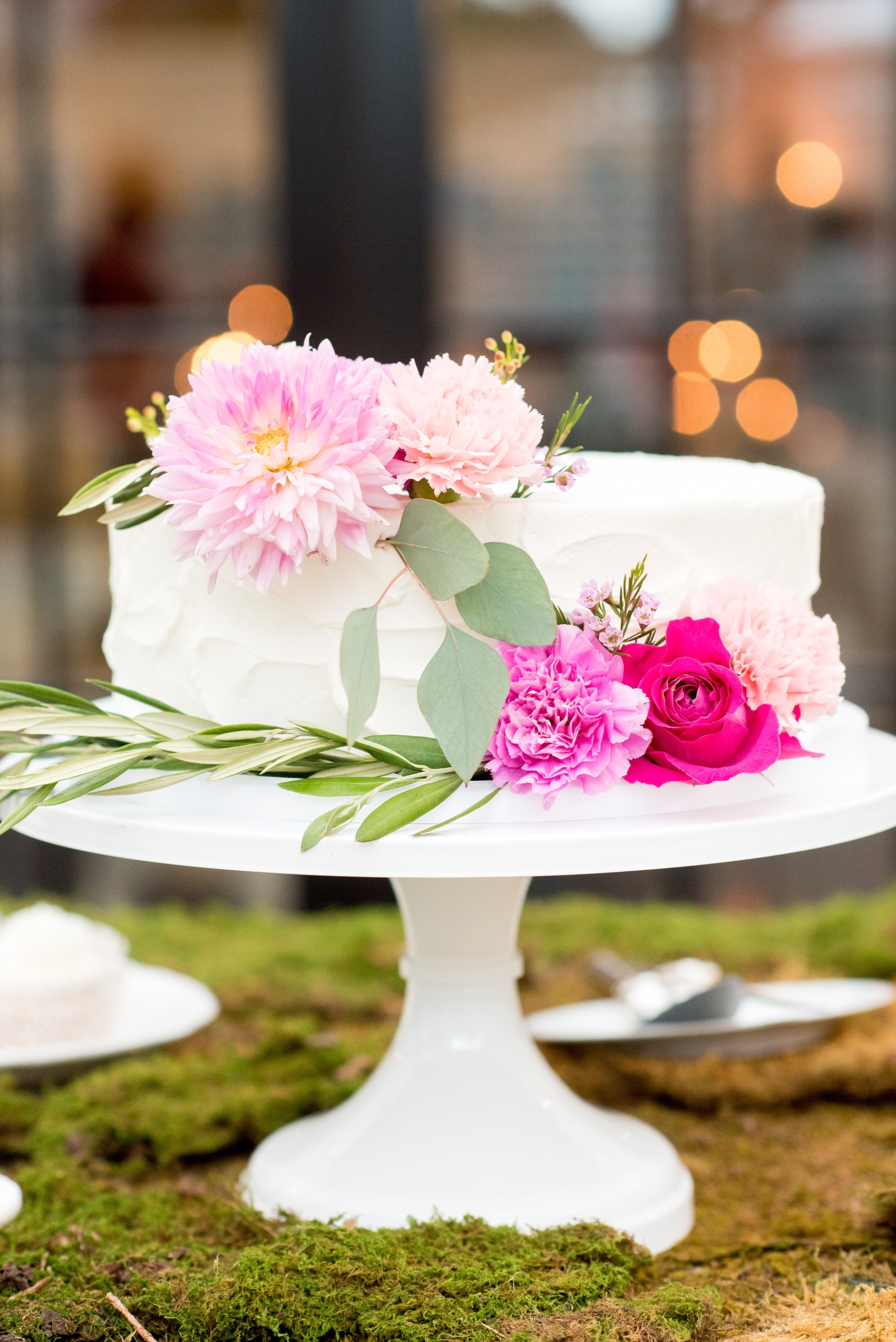 Mikkel Paige Photography wedding photos at The Merrimon-Wynne House in downtown Raleigh. A picture of the moss covered dessert table with multiple white cake and cupcakes.