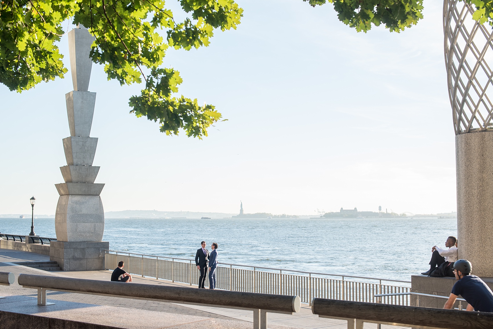 Mikkel Paige Photography photos of a same sex, gay engagement session in lower Manhattan's financial district with the Statue of Liberty in the distance.