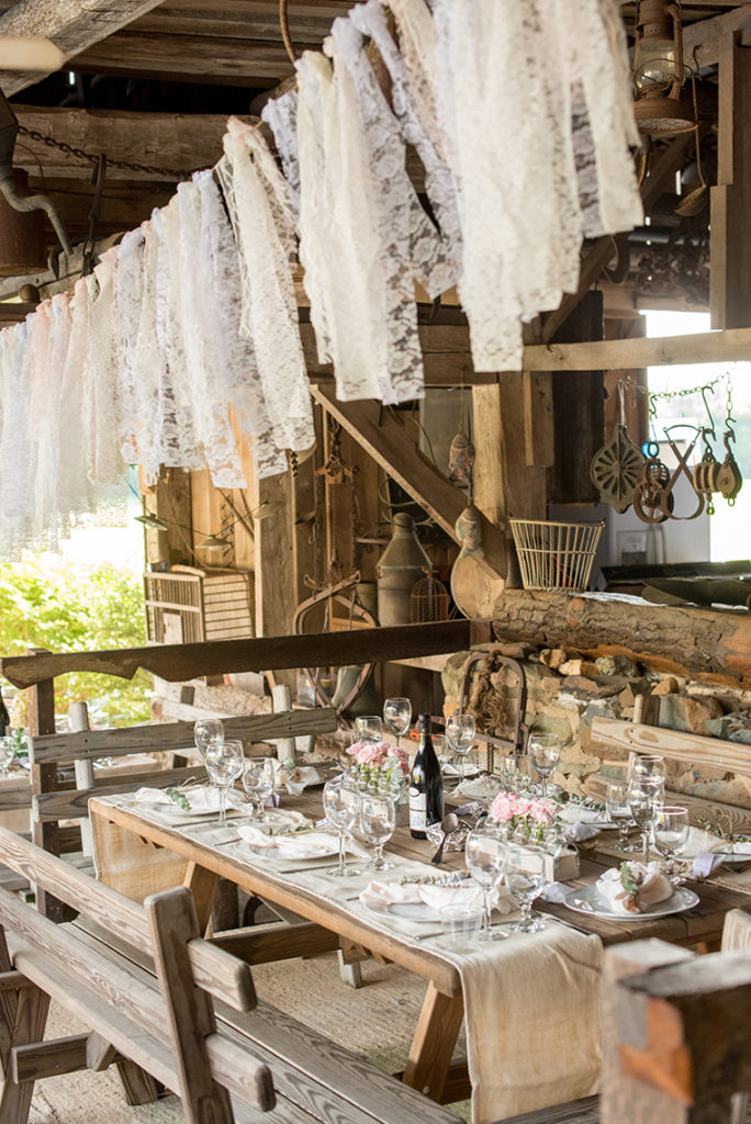 Mikkel Paige Photography photo of a rustic chic farm wedding at Spring Hill Manor, Maryland. Lace garland and wood tables with bud vases with lavender, peony and snapdragon flowers.