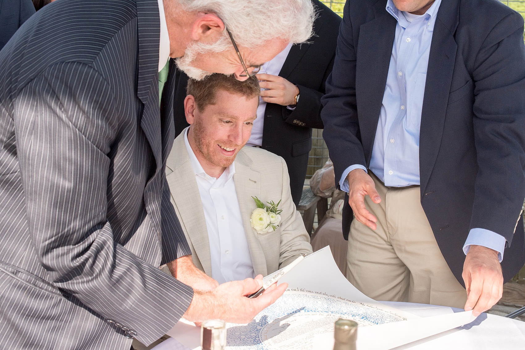 Mikkel Paige Photography photos of a wedding at Spring Hill Manor in Maryland. Image of the groom signing the Jewish marriage license ketubah.