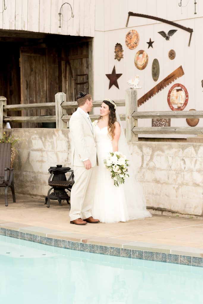 Mikkel Paige Photography photos of a wedding at Spring Hill Manor in Maryland. Image of the bride and groom by the outdoor pool and stone wall.