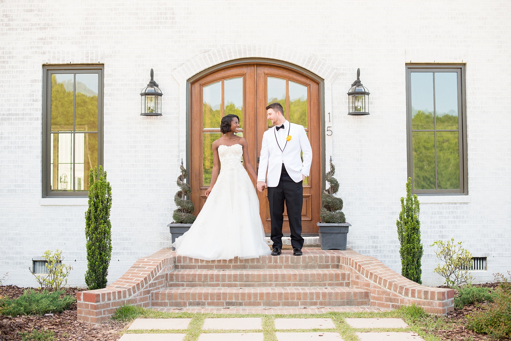 Mikkel Paige Photography photo at The Bradford, NC. Bride and groom of mixed race on the steps of the elegant NC home.