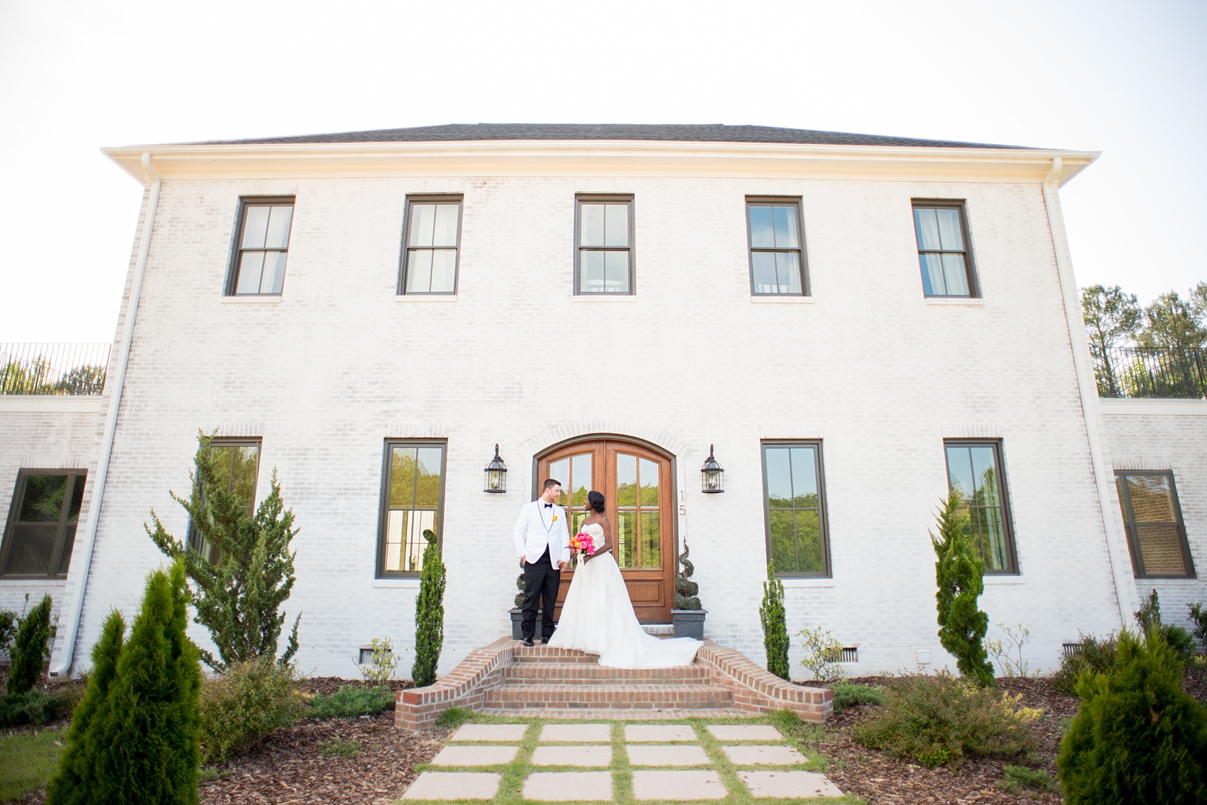 Mikkel Paige Photography photo at The Bradford, NC. Bride and groom of mixed race on the steps of the elegant NC home.