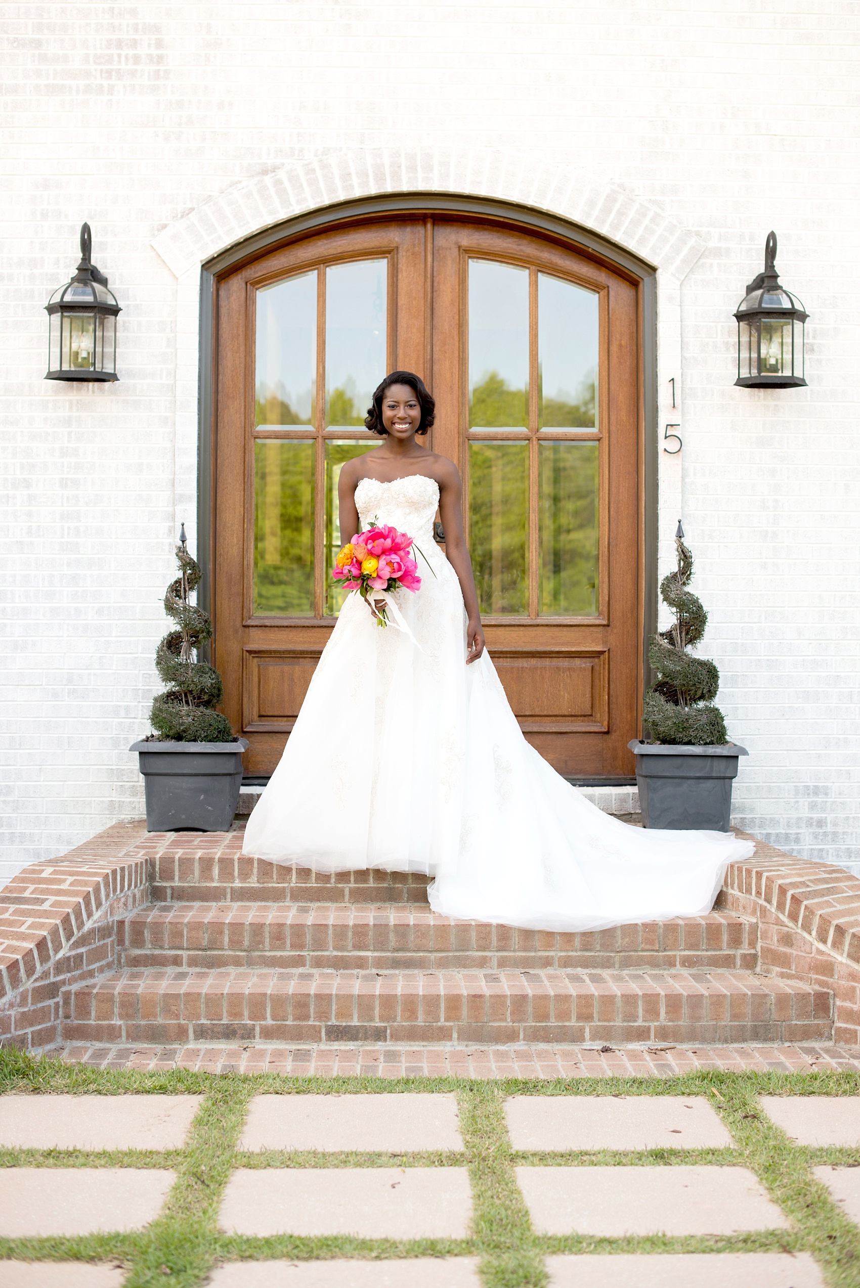 Mikkel Paige Photography wedding photo at The Bradford, NC. Bride in a strapless white gown on the steps of the elegant NC home.