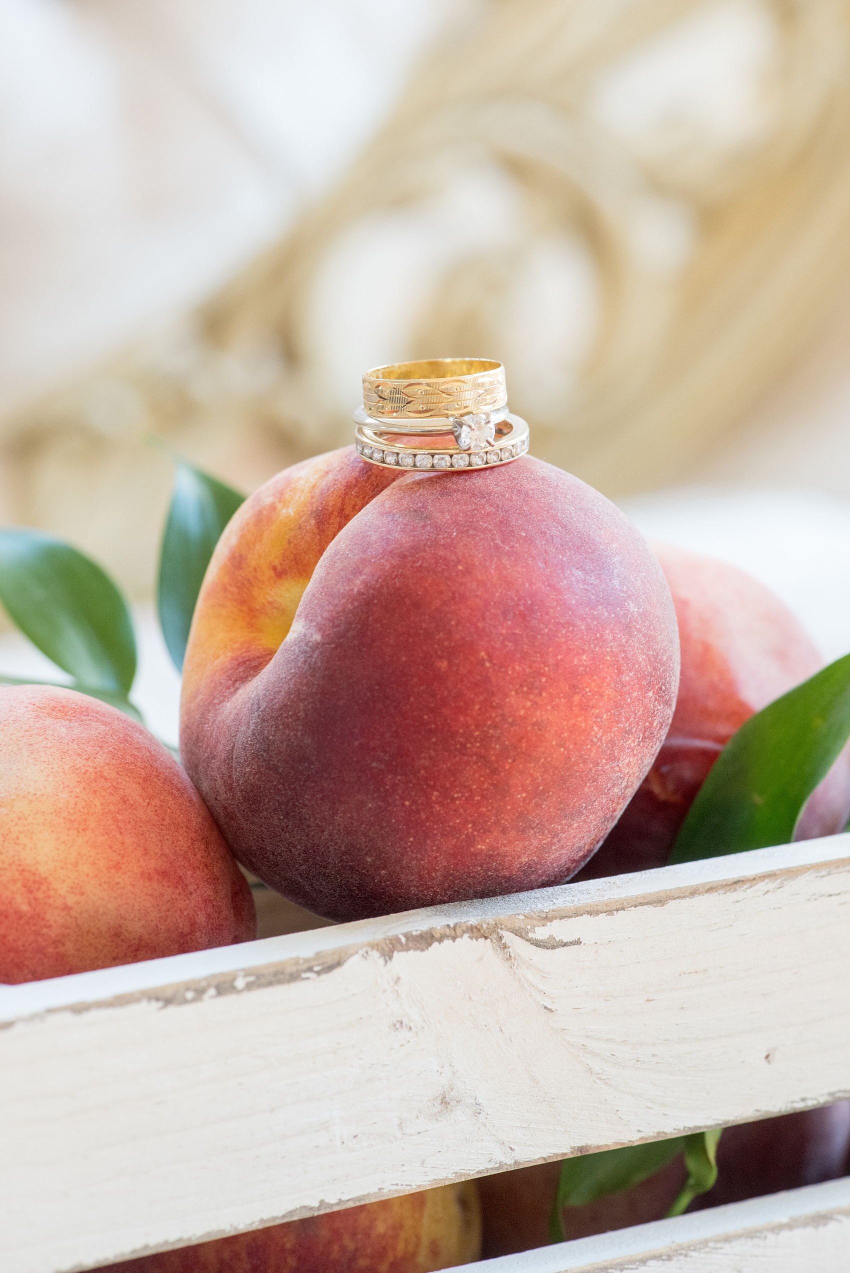 Mikkel Paige Photography photo at The Bradford, NC. Yellow gold wedding bands and rings on a bunch of peaches.