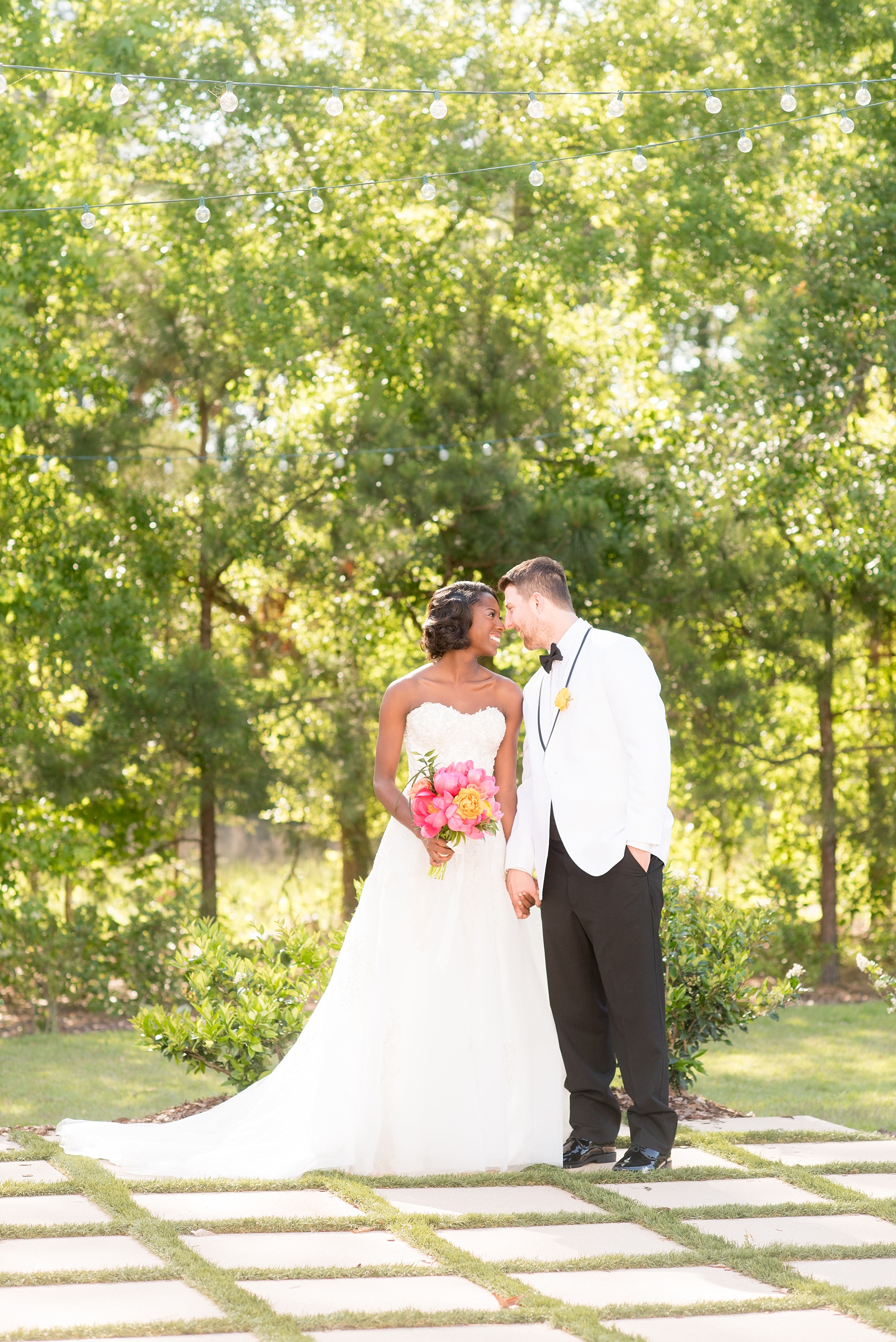 Mikkel Paige Photography photo at The Bradford, NC. Bride and groom of mixed race on the brick and green grass lined exterior patio.