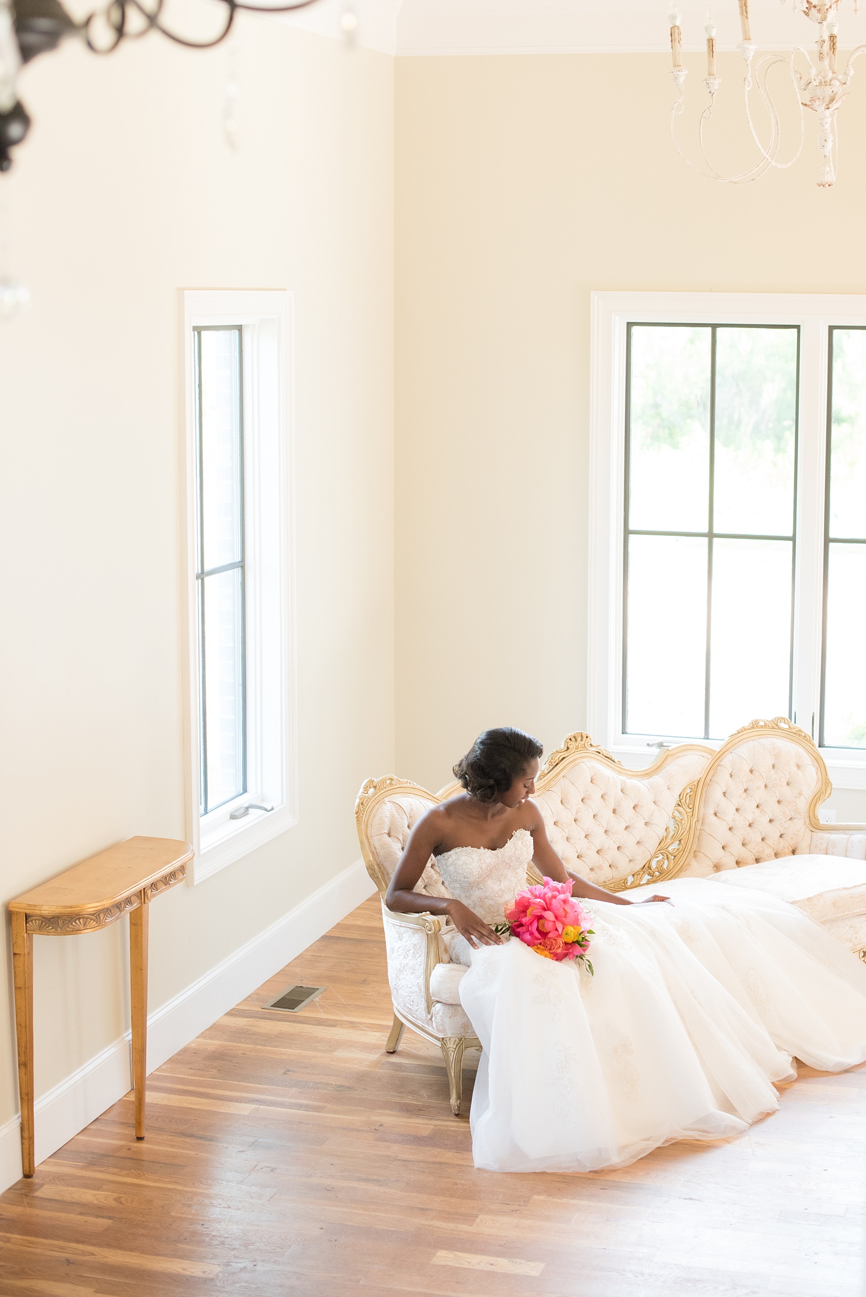 Mikkel Paige Photography photo at The Bradford, NC. Bride on an ivory sofa inside the elegant NC home.