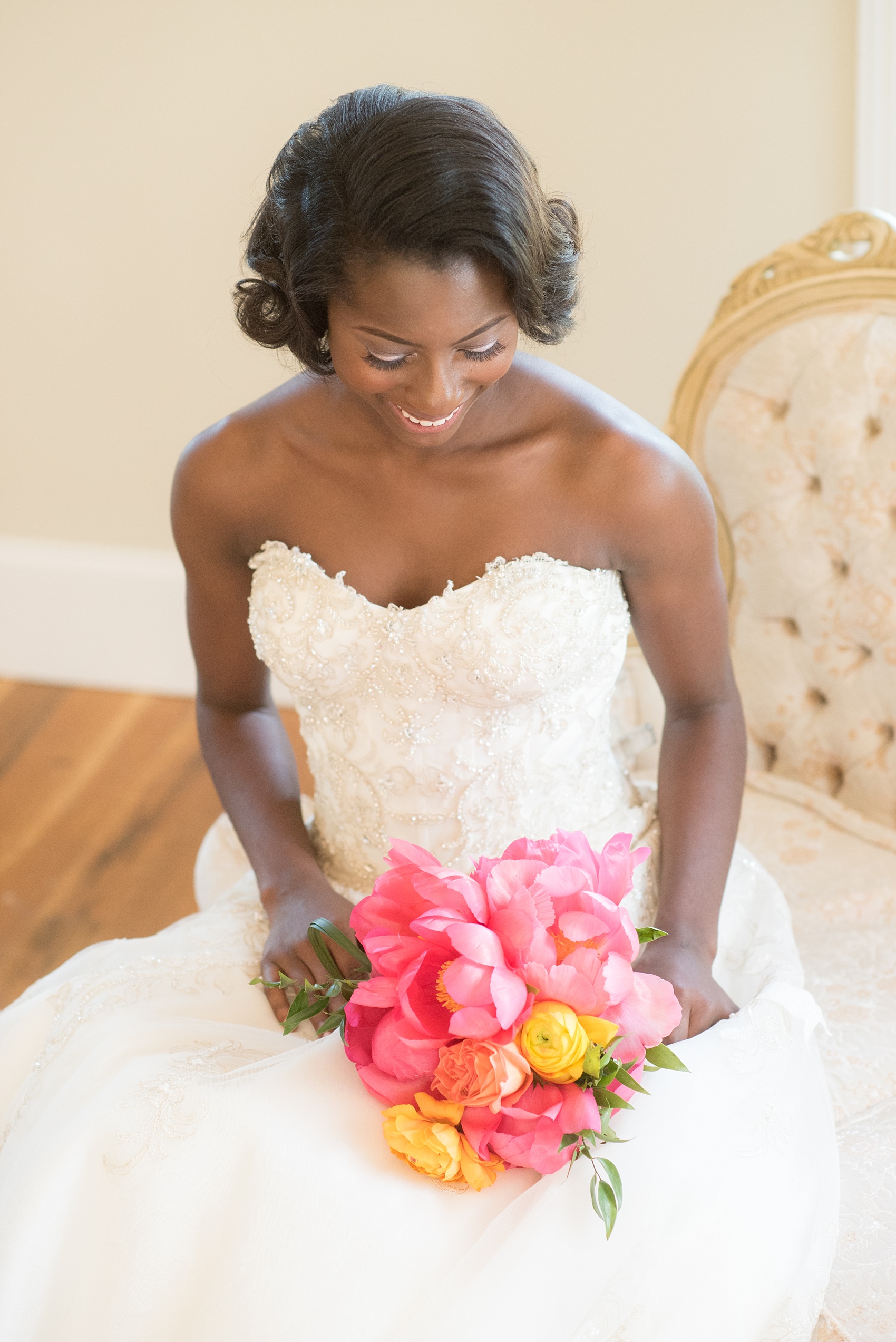 Mikkel Paige Photography photo at The Bradford, NC. Bride in a strapless gown on an ivory sofa inside the elegant NC home.