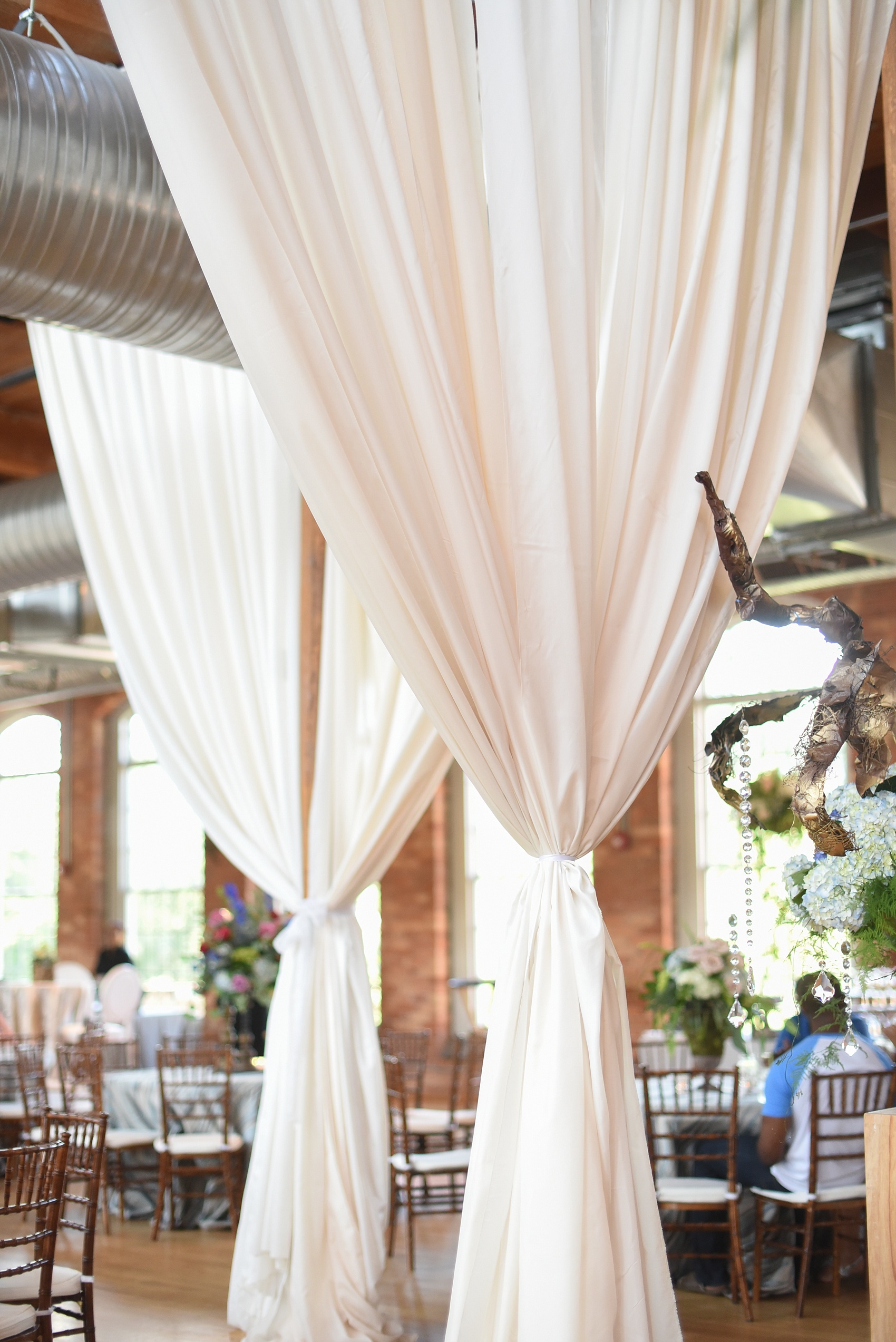 Mikkel Paige Photography photos from The Cotton Room wedding venue in Durham, NC. Cotton linen draped from the ceiling rafters served as elegant room dividers and accents.