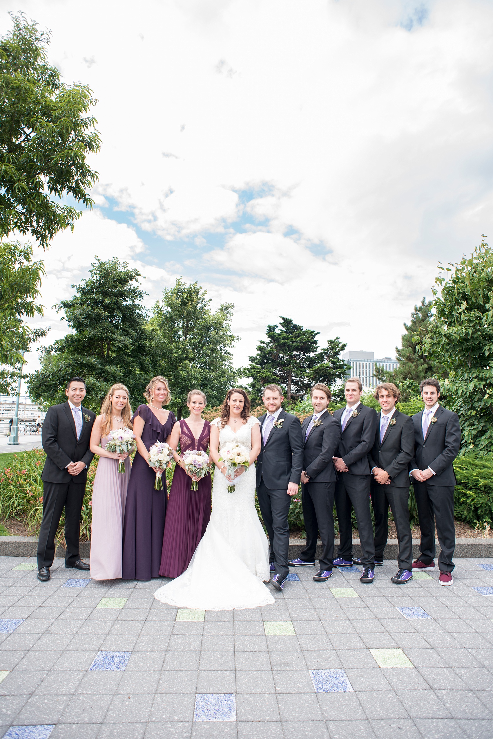 Mikkel Paige Photography photos of a NYC wedding at Tribeca Rooftop. Photos of the bridal party in purple hues and custom Converse at Hudson River Park.
