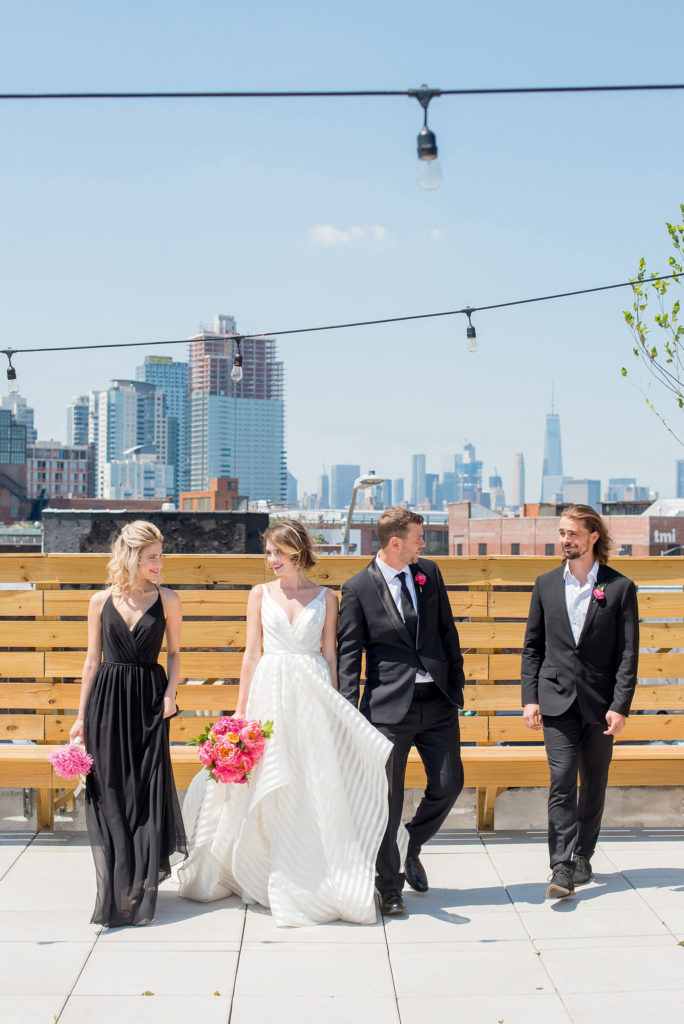 Mikkel Paige Photography photo of Dobbin St Brooklyn wedding. Planning and coordination by Color Pop Events. Rooftop photos in Williamsburg with the Empire State Building and Freedom Tower behind the bridal party.