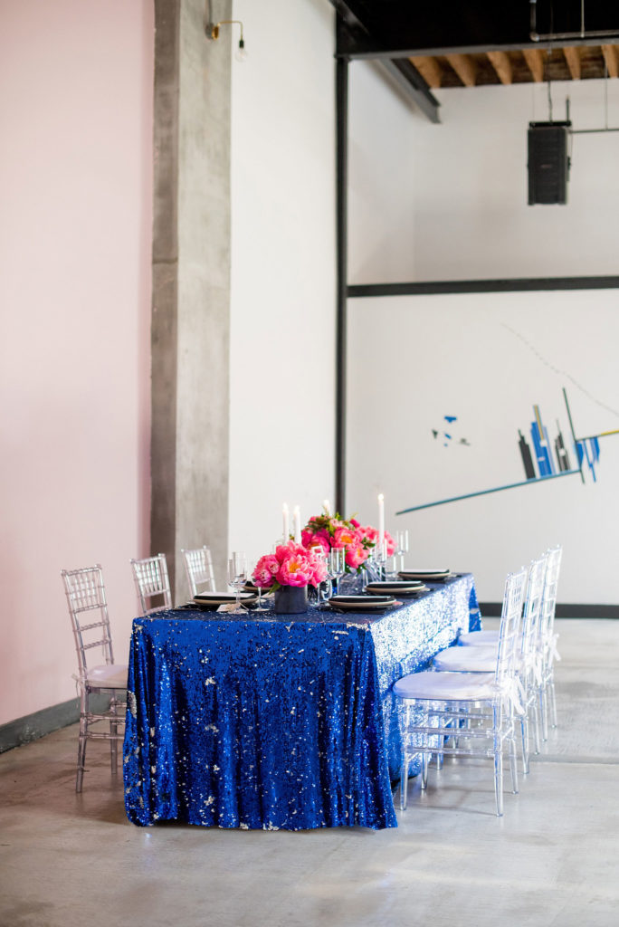 Mikkel Paige Photography photo of Dobbin St Brooklyn wedding. Planning and coordination by Color Pop Events. Reception table with blue sequins, pink peony centerpieces and clear chiavari chairs.